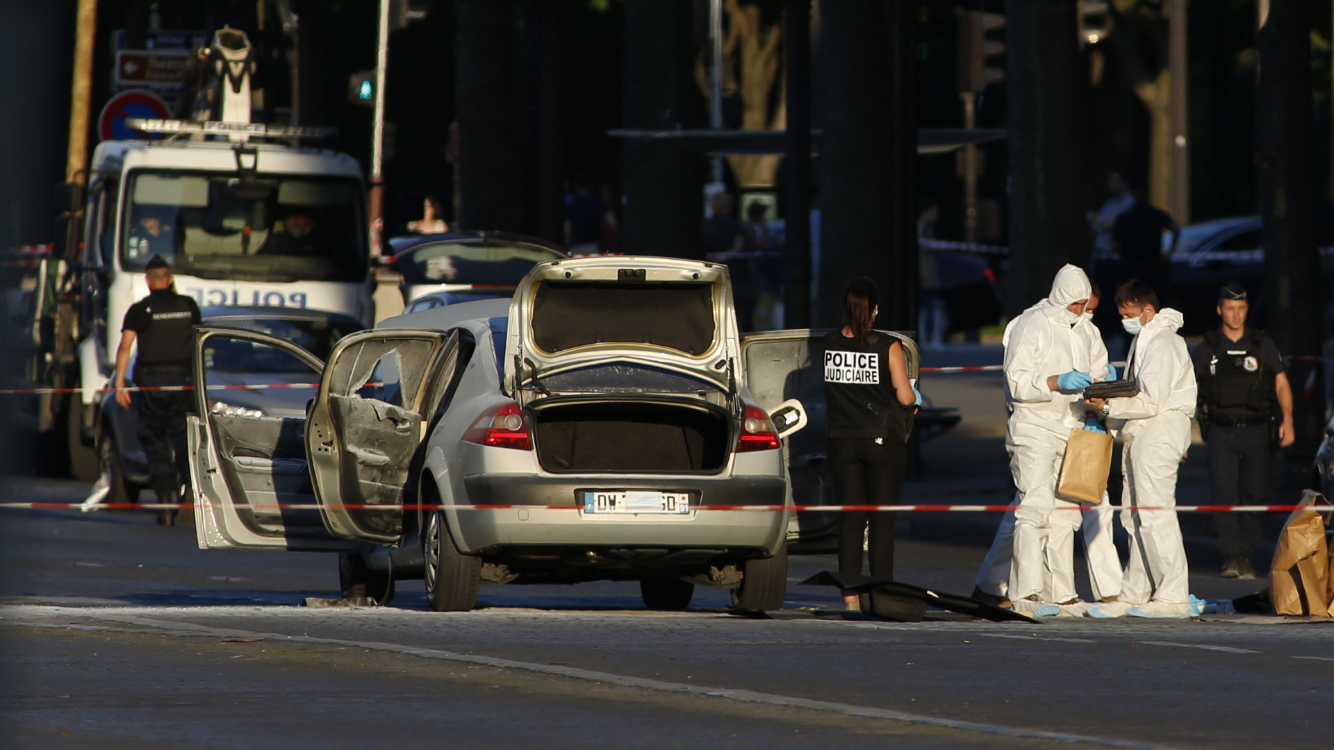 Nach dem mutmaßlichen Anschlag auf Polizisten auf den Pariser Champs-Élysées untersuchen Beamte das Fahrzeug des Angreifers. | Bildquelle: AP