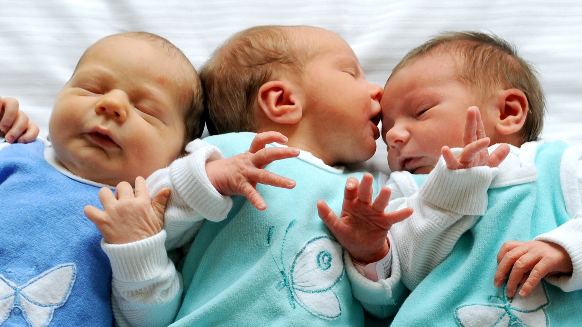 Drei Neugeborene liegen in der Wochenstation der Universitätsfrauenklinik in Leipzig in einem Bett. | Bildquelle: dpa