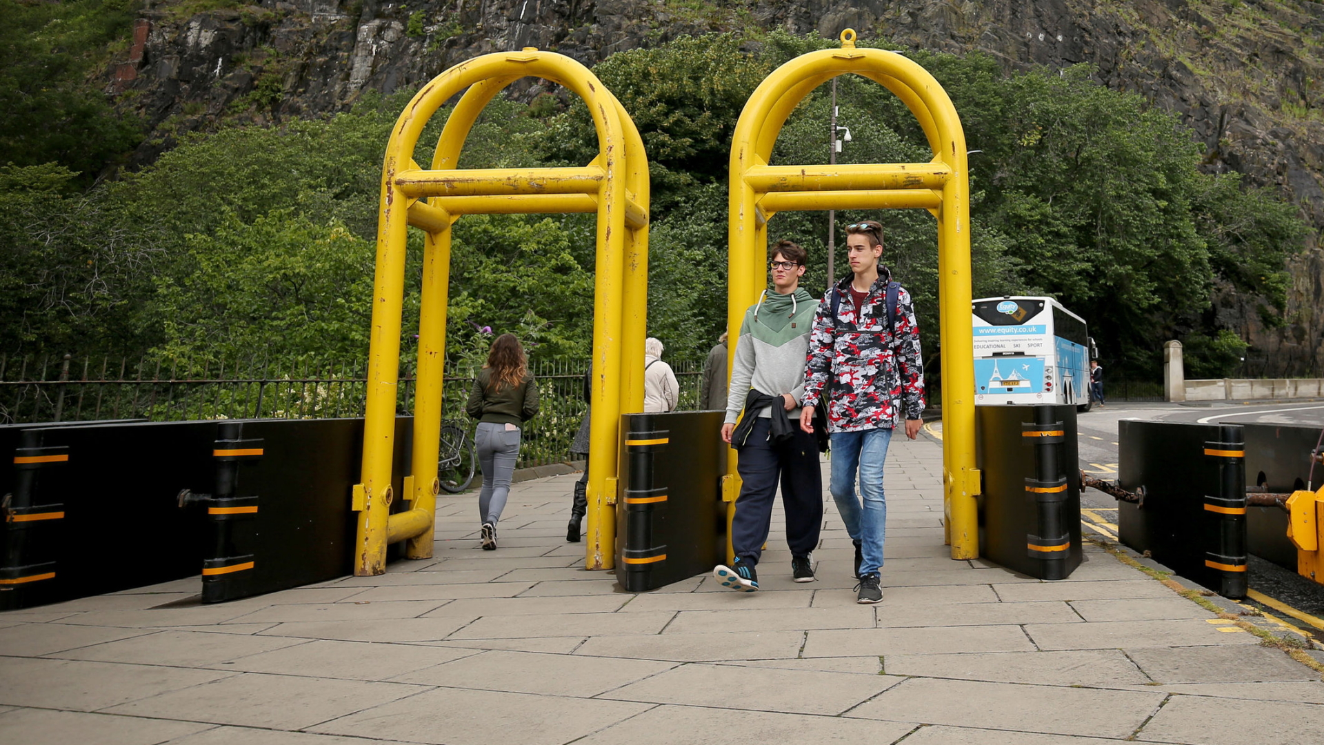 Menschen gehen in Edinburgh durch neue Sicherheitsbarrieren, die dazu installiert wurden, um Terroristen daran zu hindern, mit Fahrzeugen in Fußgänger hineinzufahren. | Bildquelle: dpa