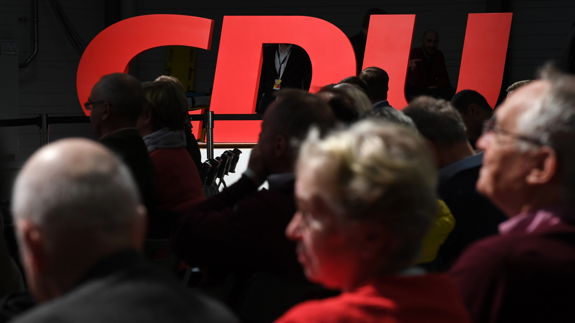 Der angestrahlte Schriftzug der CDU hinter einer Menschengruppe. | Bildquelle: dpa