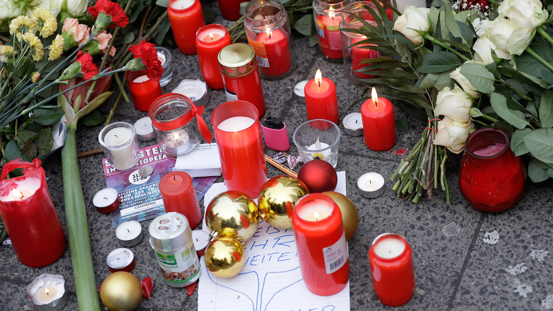 Kerzen und Blumen liegen in der Nähe des Weihnachtsmarkts an der Gedächtniskirche | Bildquelle: AP