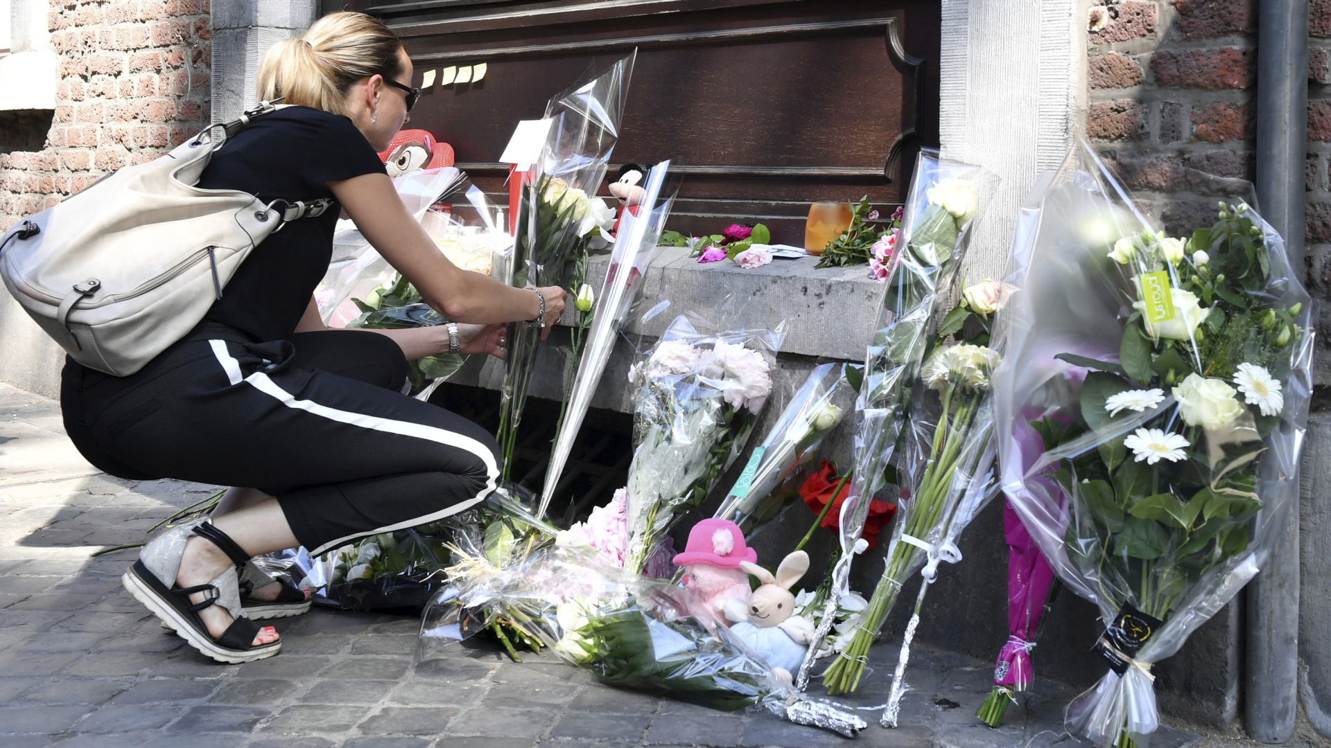 Eine Frau legt Blumen nach dem Attentat von Lüttich ab. | Bildquelle: dpa