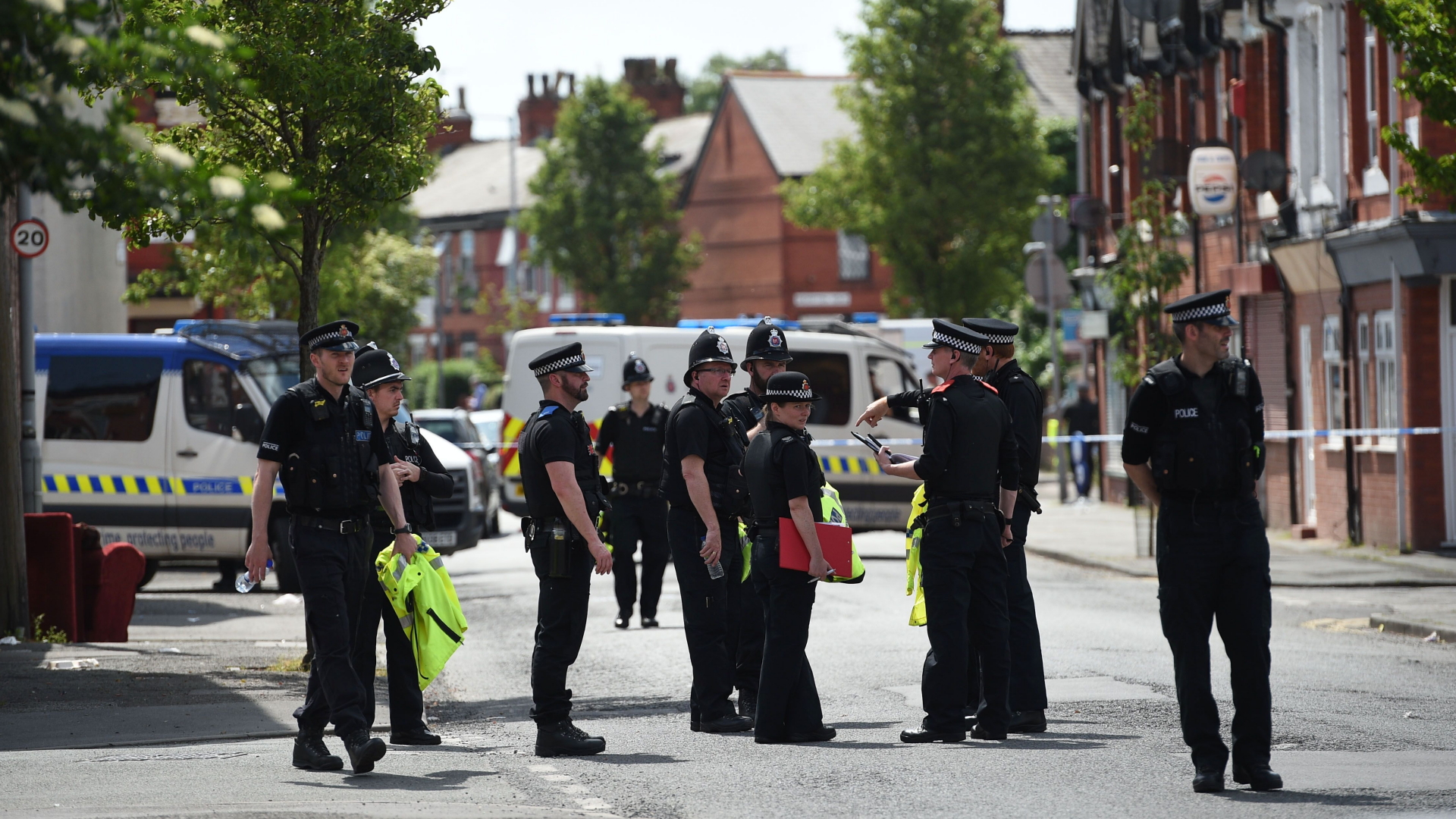 Polizisten stehen während eines Einsatzes auf einer Straße in Manchester. | Bildquelle: AFP