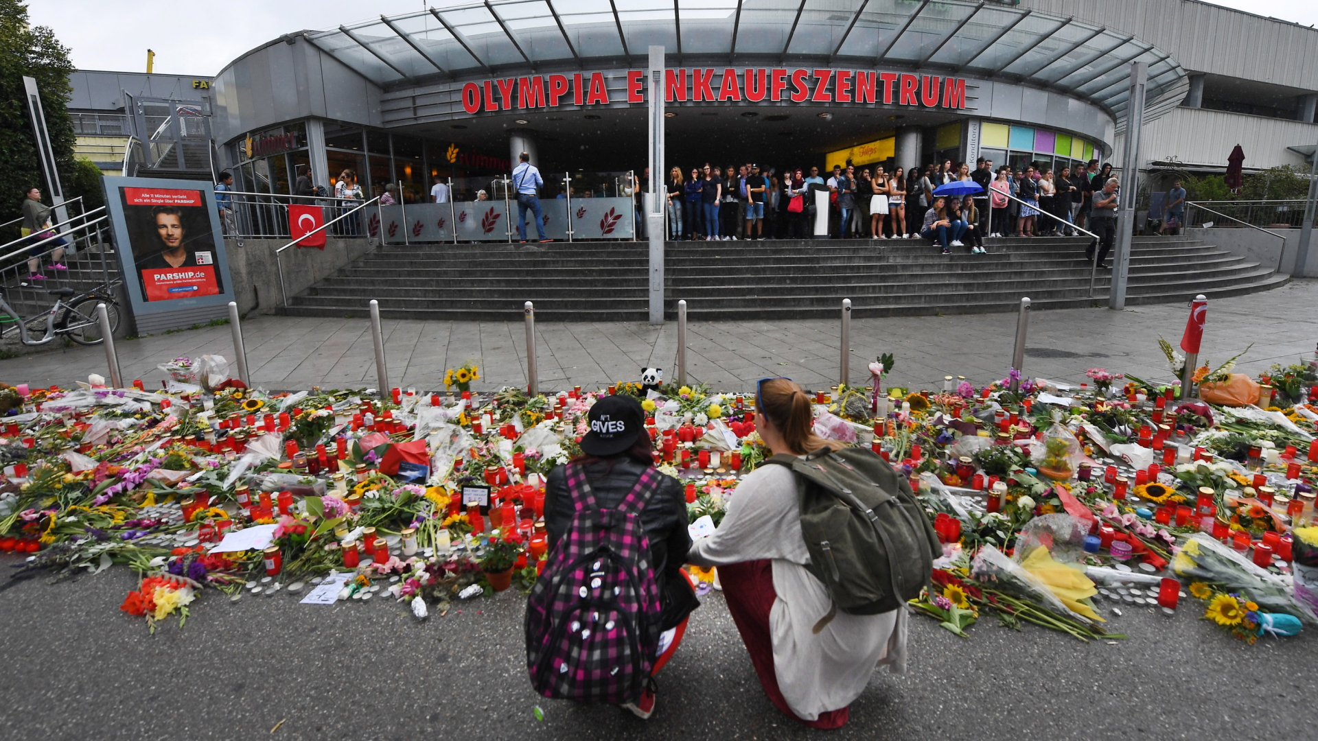 Menschen legen Blumen am Tatort in München nieder. | Bildquelle: dpa