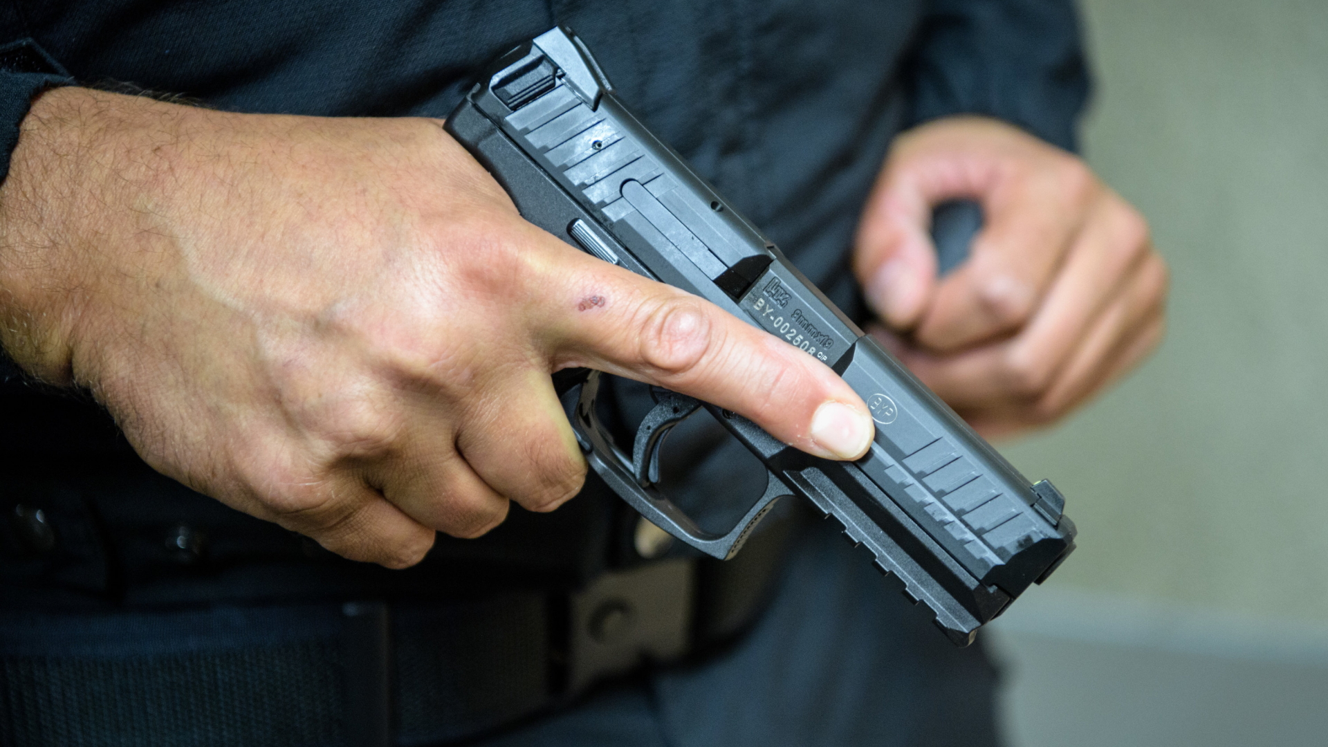 Ein Mann hält die Dienstpistole SFP9-TR von Heckler & Koch in der Hand. | Bildquelle: dpa