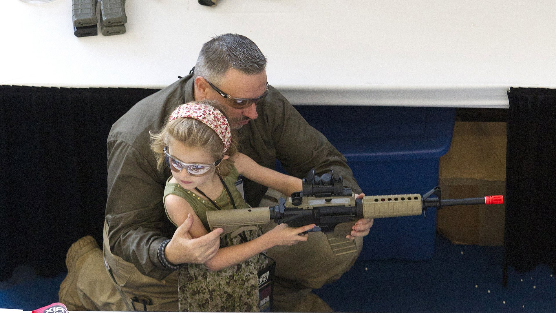 Ein Mann hält zusammen mit einem Kind eine Waffe in den Händen | Bildquelle: picture alliance / AP Photo