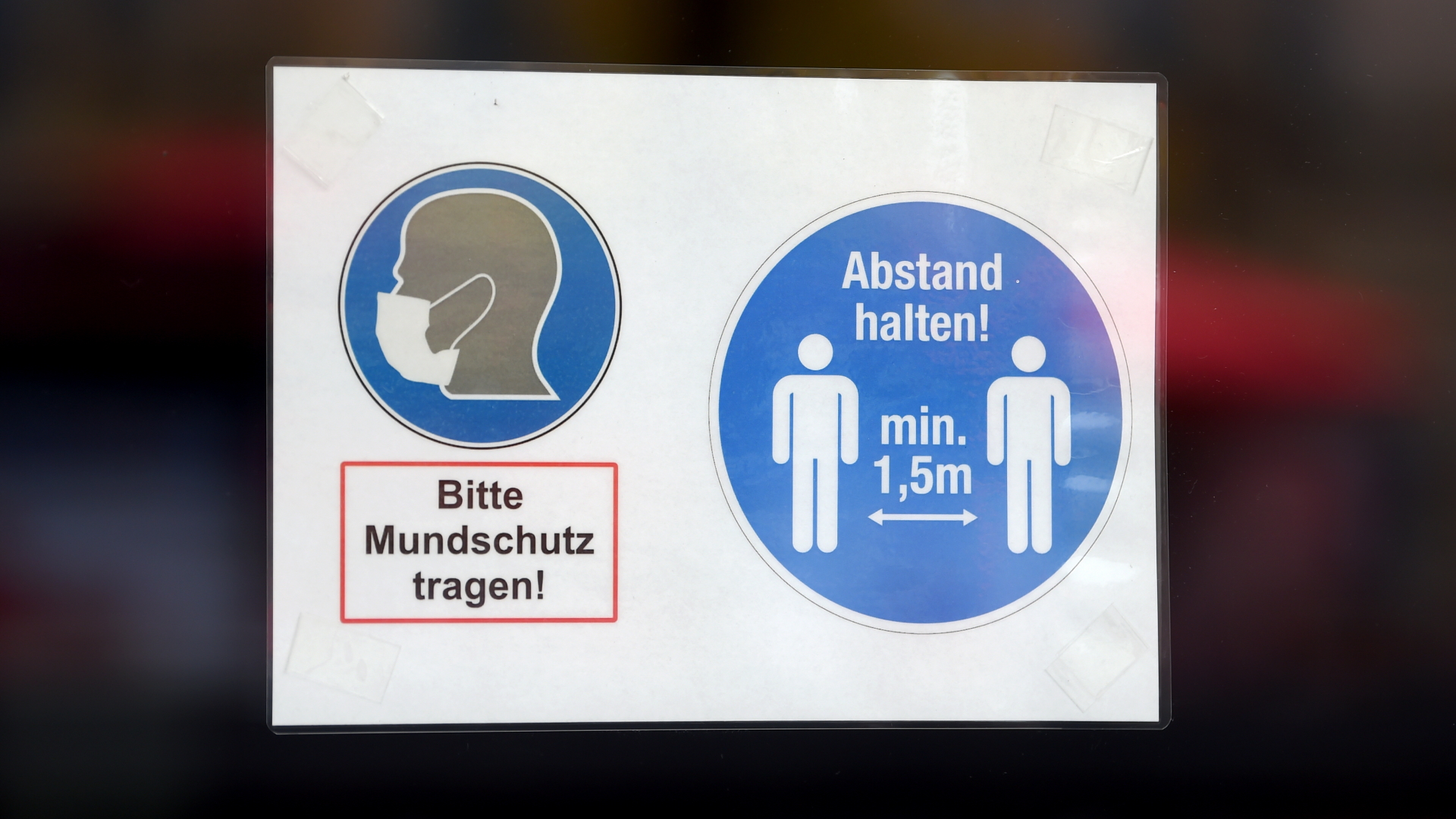 An der Tür eines Geschäfts in Berlin hängt ein Schild mit der Aufschrift "Bitte Mundschutz tragen!" und "Abstand halten! min. 1,5m" | dpa