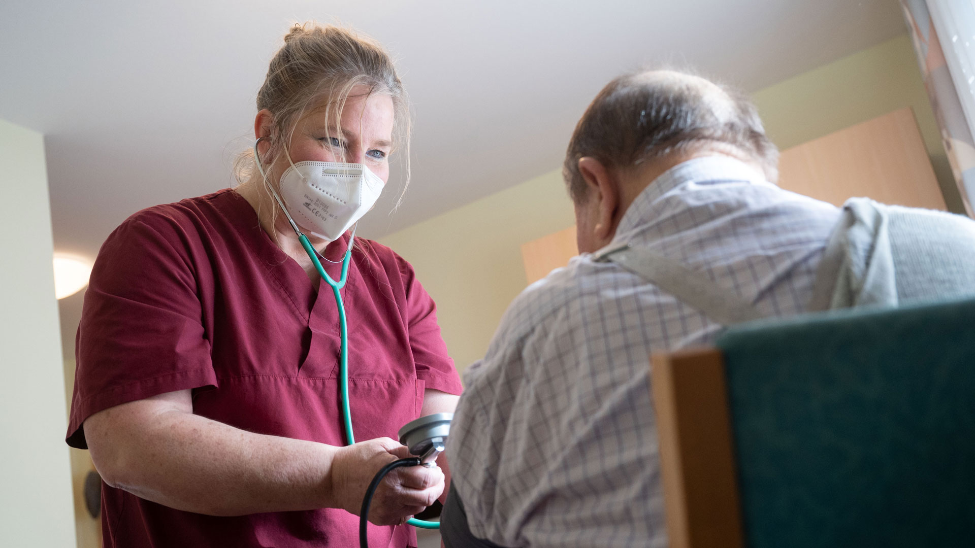 Eine Mitarbeiterin des Seniorenhaus im Vorbachtal betreut einen Bewohner des privaten Pflegeheims. | picture alliance/dpa