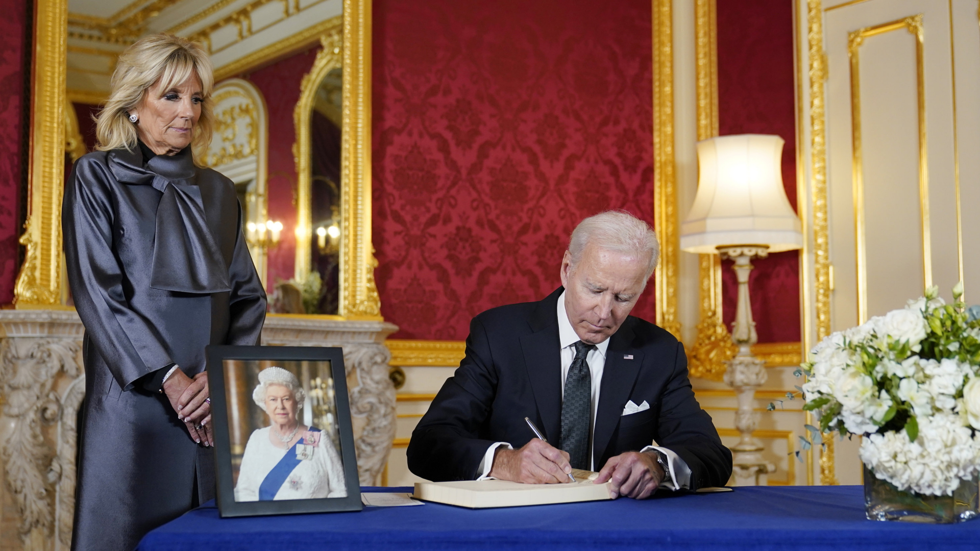 Präsident Joe Biden trägt sich nach dem Tod von Königin Elisabeth II. im Lancaster House in London in ein Kondolenzbuch ein, während First Lady Jill Biden zusieht. | AP