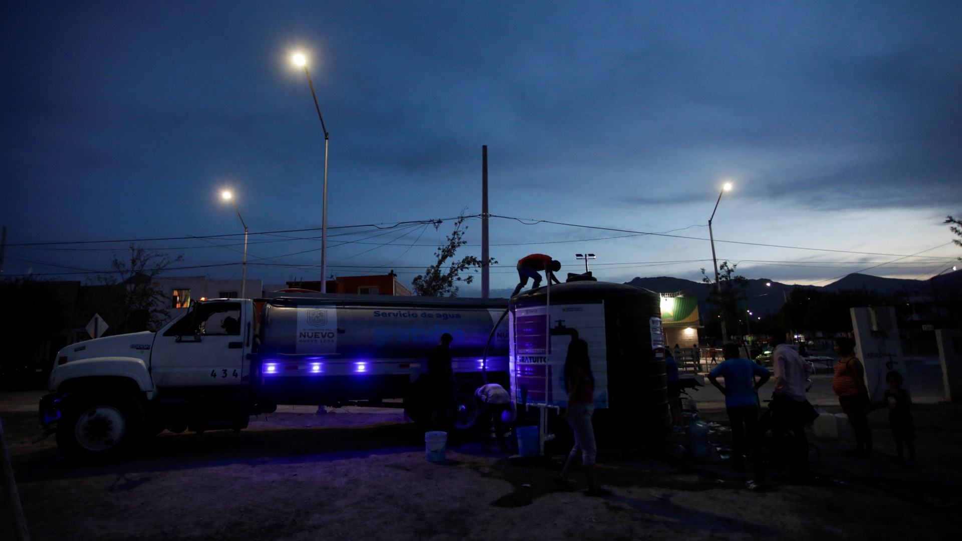 Menschen bilden in García im Nordosten Mexikos eine Schlange vor der Wasserausgabe an einem Tanklaster. | REUTERS