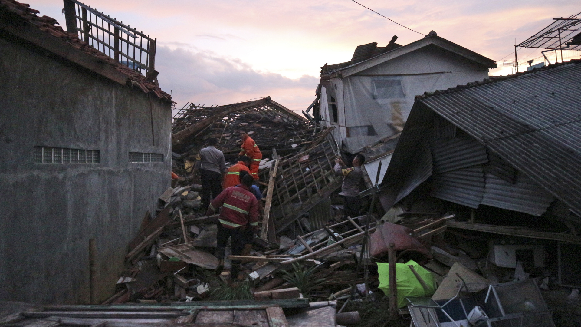 Rettungskräfte suchen nach Überlebenden in den Ruinen von Häusern, die durch ein Erdbeben in Indonesien beschädigt wurden. | Rangga Firmansyah/AP/dpa-Bildfunk