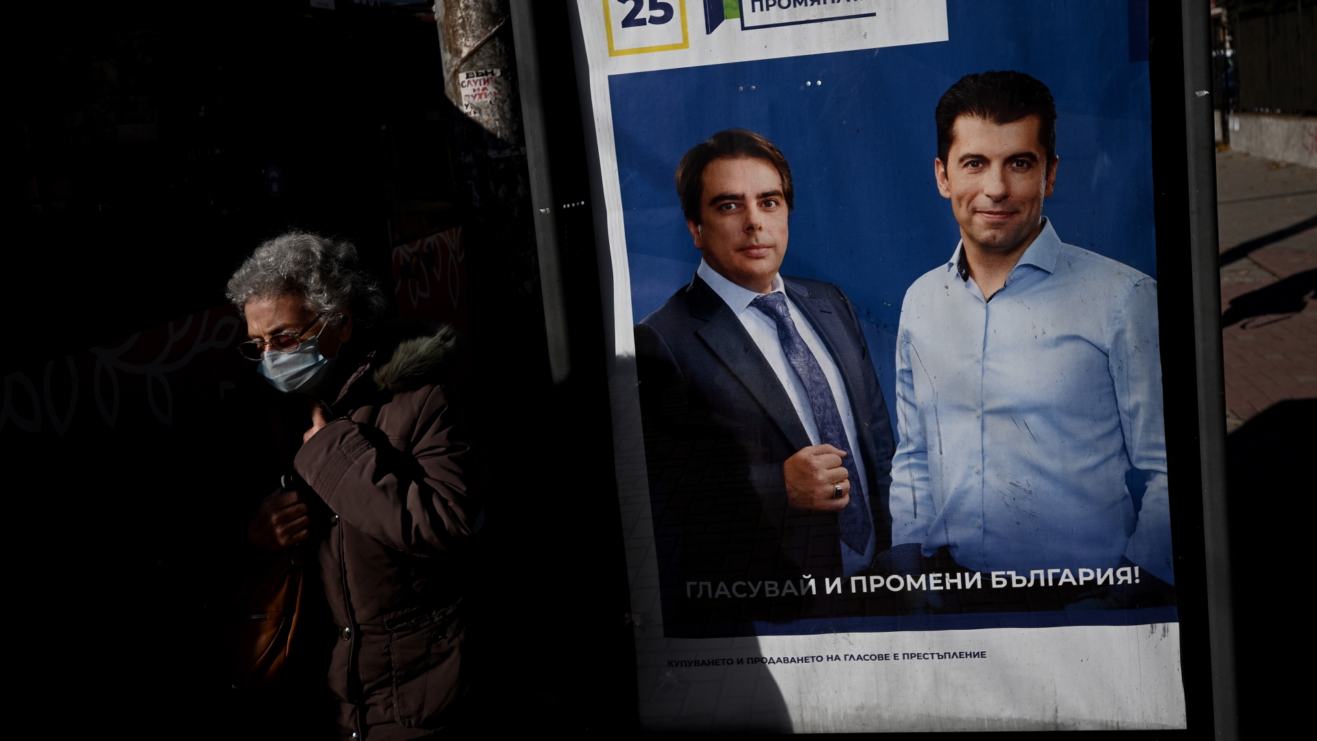 Eine Frau läuft an einem Wahlplakat der Partei "Wir setzen den Wandel fort" vorbei, auf dem die Spitzenkandidaten Kiril Petkow (rechts) und Assen Wassilew (links) zu sehen sind. | EPA