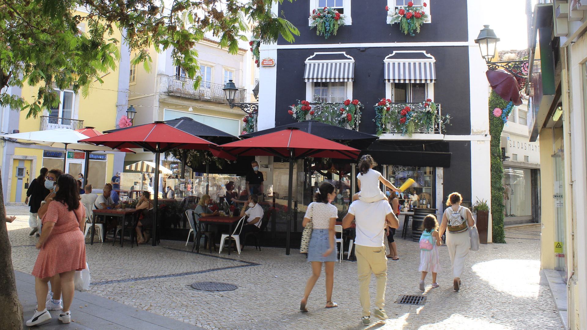 Menschen gehen am Bocage-Platz im Lissabonner Stadtteil Setubal vorbei. | dpa