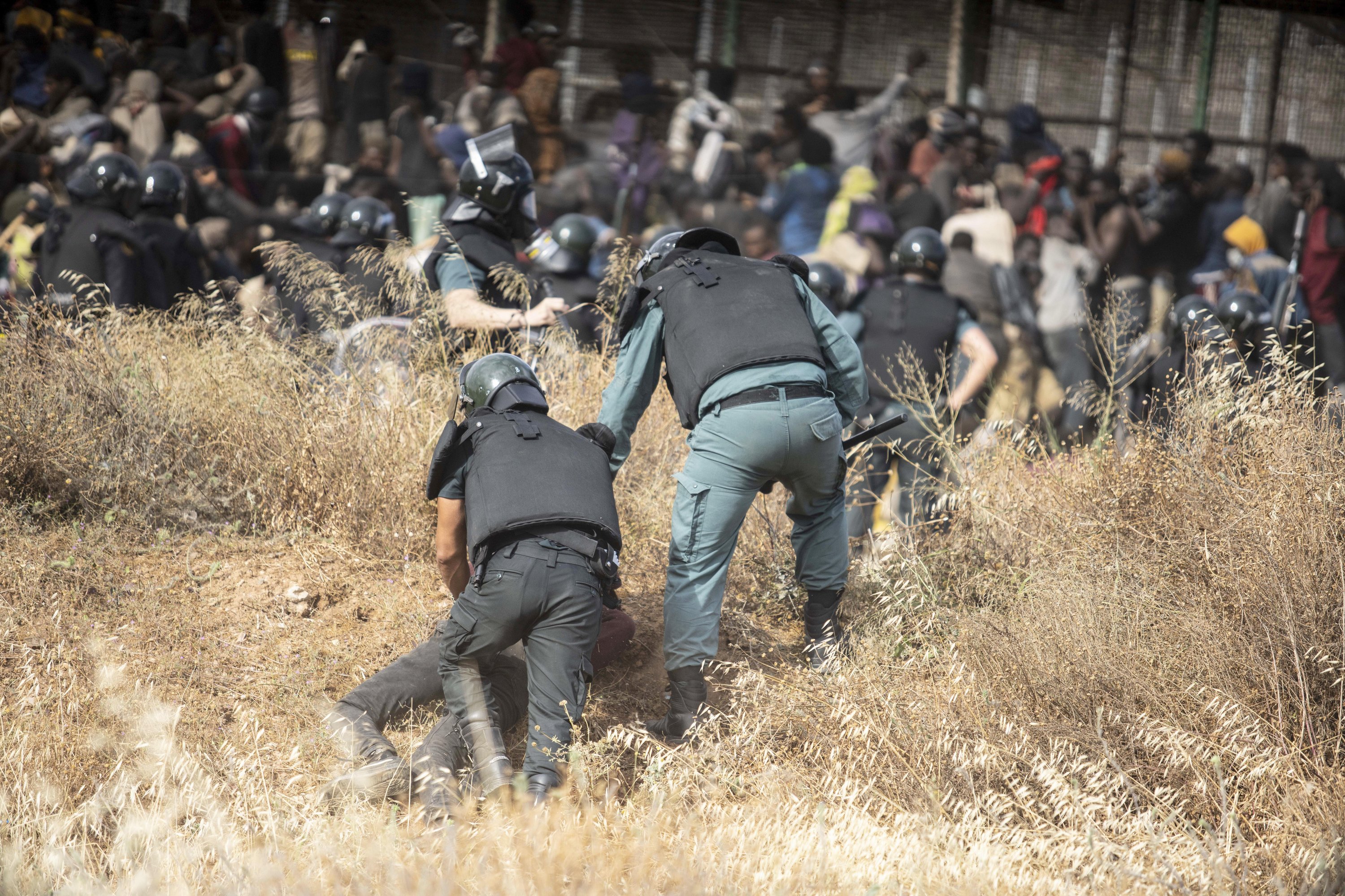 Polizist hält Migranten fest. | AP