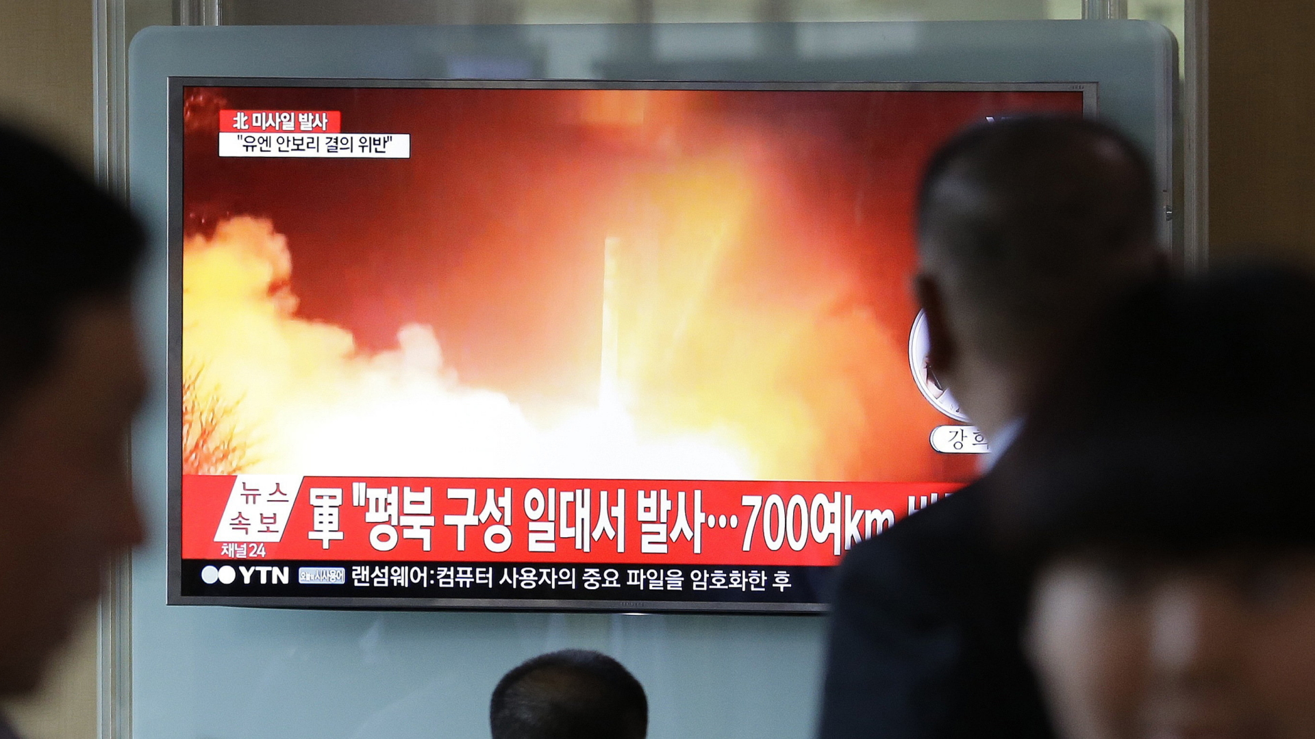 Menschen schauen am Bahnhof in Seoul in Südkorea auf einen TV-Bildschirm, auf dem eine Archivaufnahme von einem früheren nordkoreanischen Raketentest zu sehen ist.