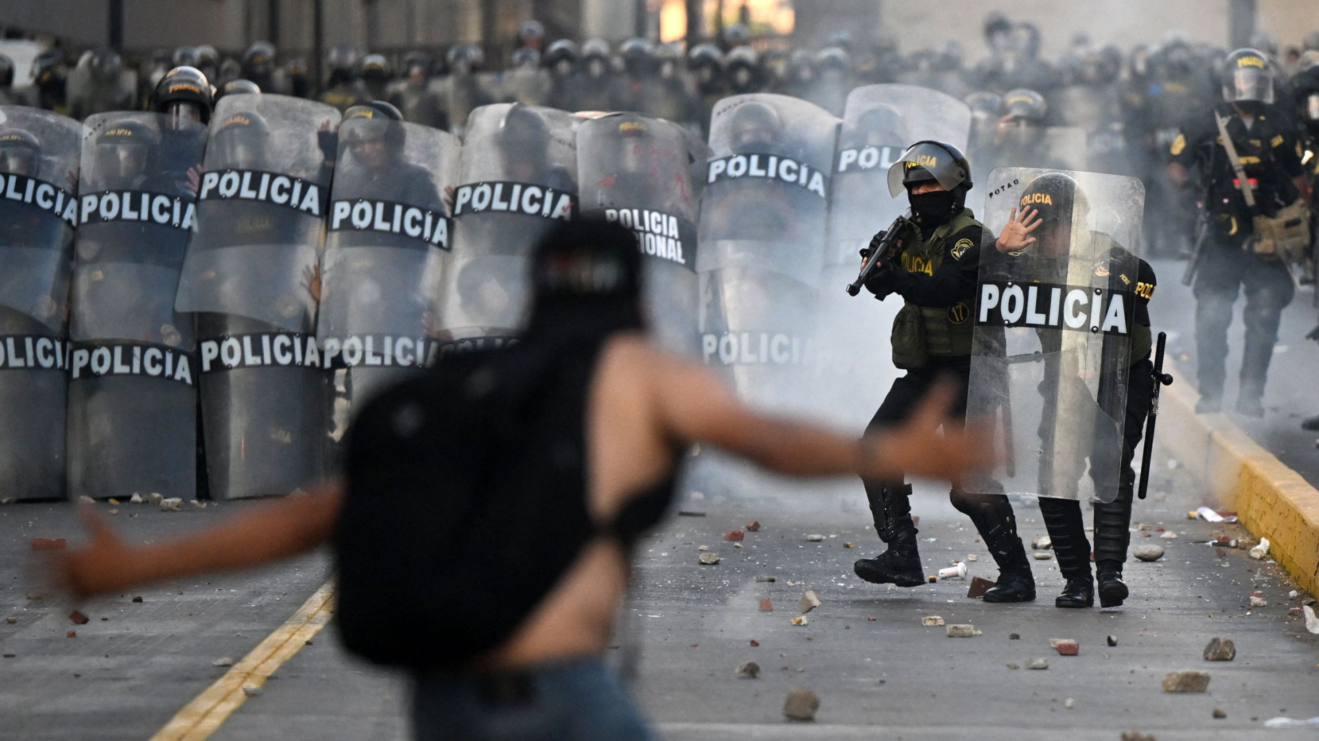 Ein Demonstrant steht vor Polizisten in Perus Hauptstadt Lima | AFP