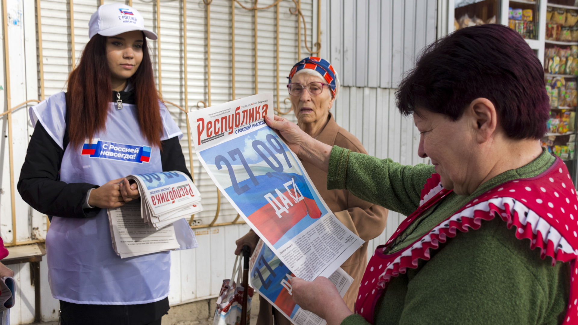 Ein Freiwilliger der regionalen Wahlkommission von Luhansk verteilt Zeitungen an die Bürger in Luhansk. | dpa