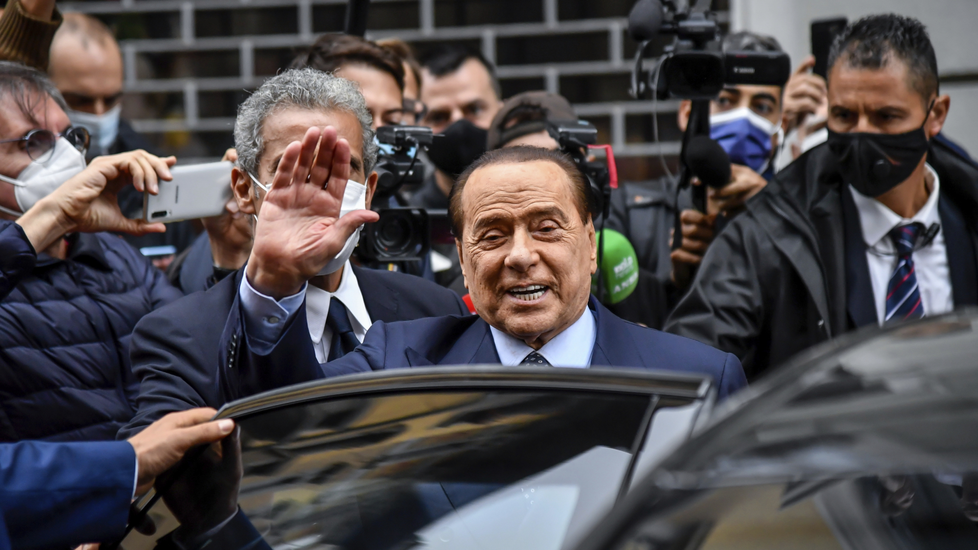Silvio Berlusconi winkt, als er nach dem Verlassen eines Wahllokals in ein Auto steigt (Archiv).