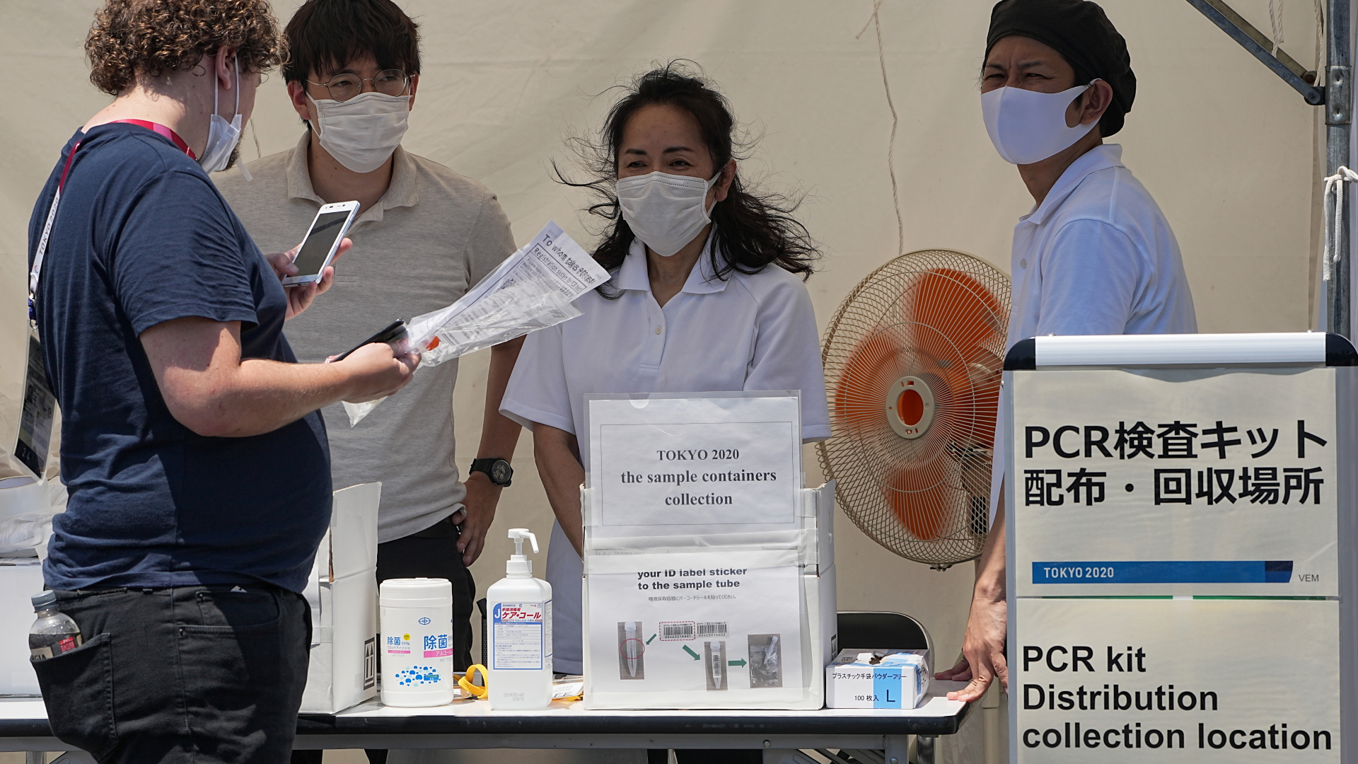 Ein Mann registriert seine Speichelprobe vom Corona-PCR-Test an einer Sammelabgabestellte in Tokio. | dpa