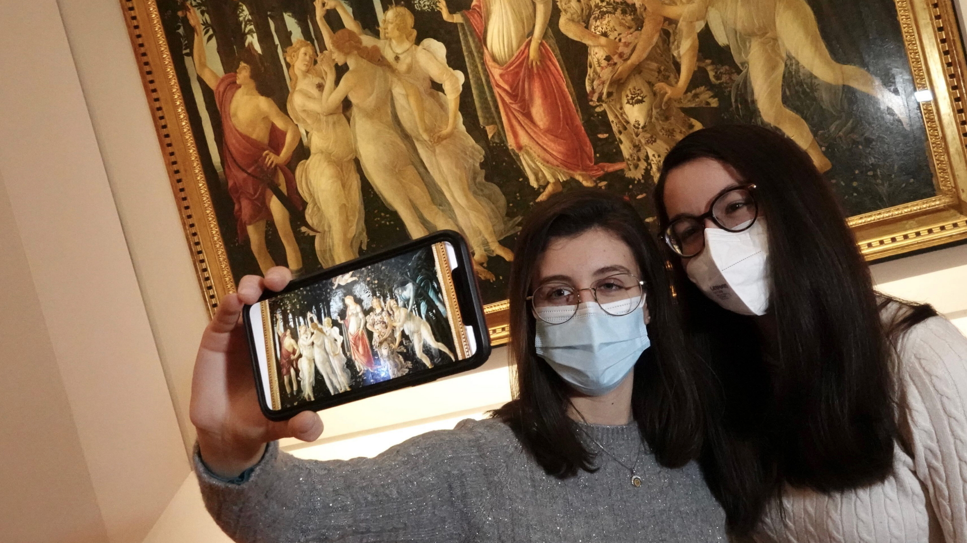 Zwei Besucherinnen mit Mund-Nasen-Schutz machen ein Selfie vor dem Kunstwerk "Primavera" (etwa um 1480) des Malers Sandro Botticelli.  | dpa