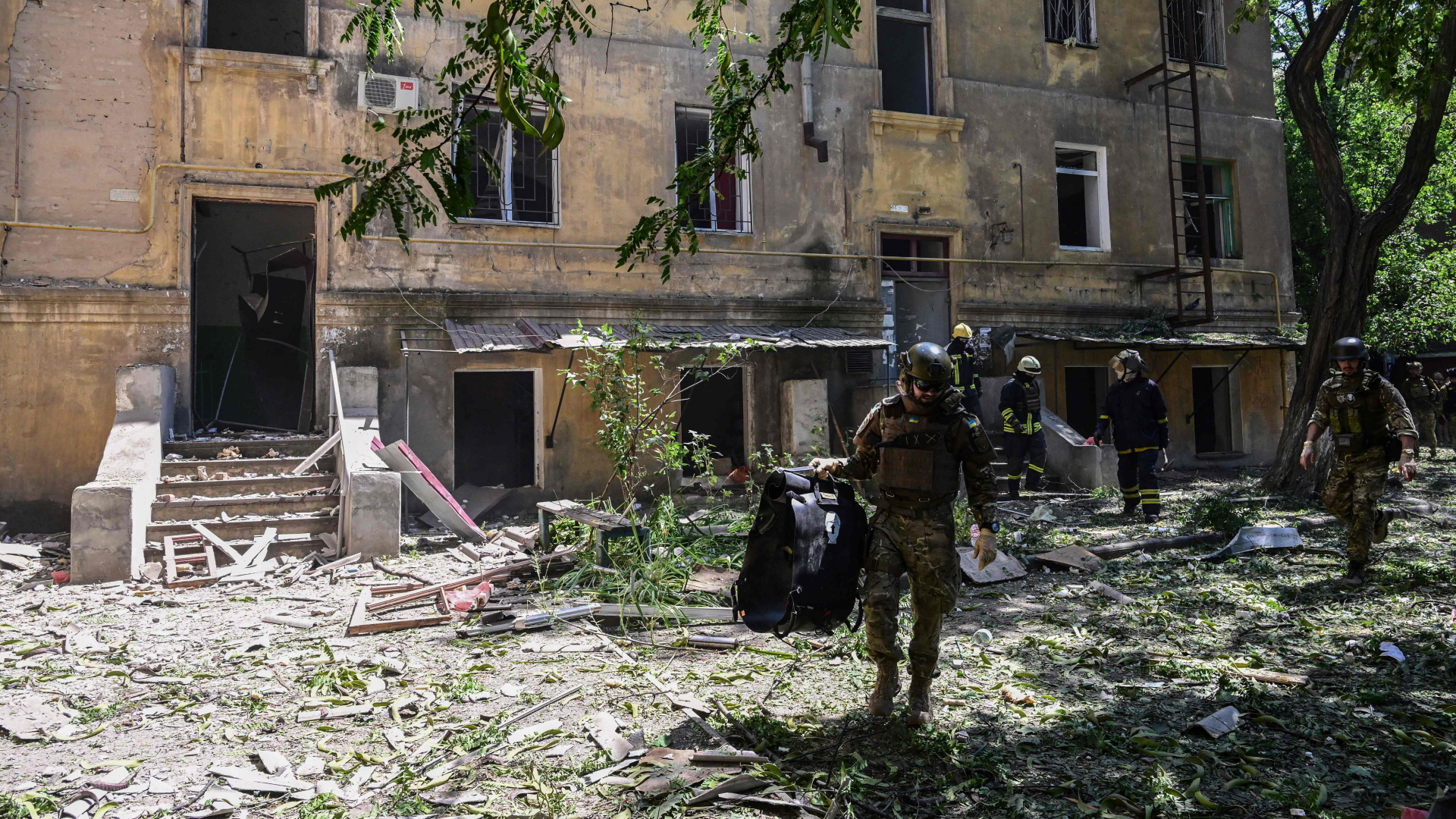 Ukrainische Soldaten und Feuerwehrmänner vor einem durch Luftangriffe beschädigten Gebäude im ostukrainischen Kramatorsk. | AFP