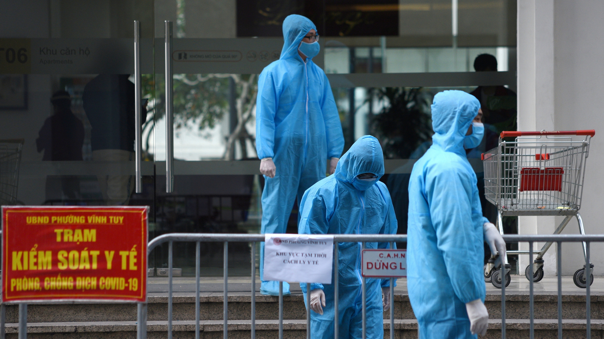 Medizinisches Personal steht in Schutzanzügen in Hanoi vor einem Gebäude (Archiv). | REUTERS