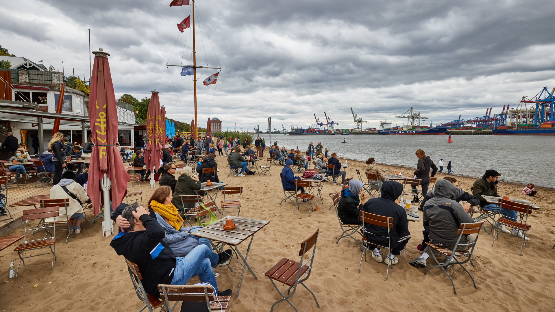 Menschen sitzen draußen vor dem Café Strandperle in Hamburg | dpa