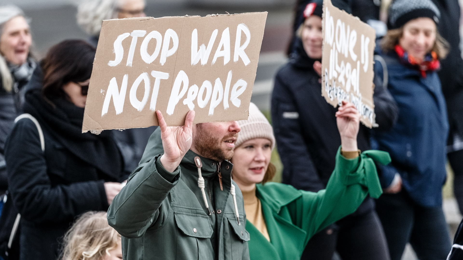 "Stop war, not people" steht auf einem Plakat, das ein Demonstrant in Hamburg hochhält. | dpa