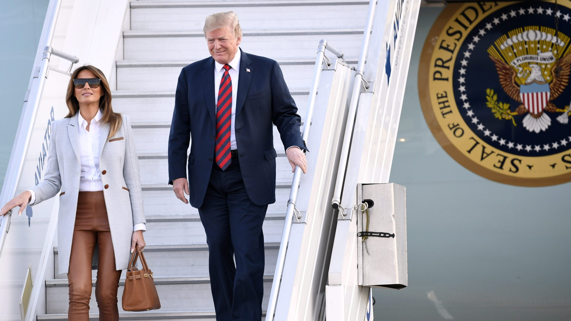 US-Präsident Donald Trump und Melania Trump steigen die Treppe der Air Force One hinab | AFP