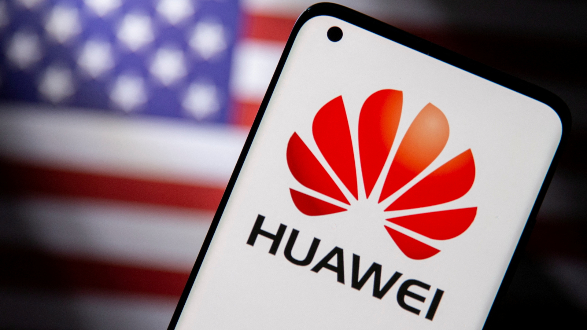 Ein Smartphone mit dem Huawei-Logo vor der US-Flagge