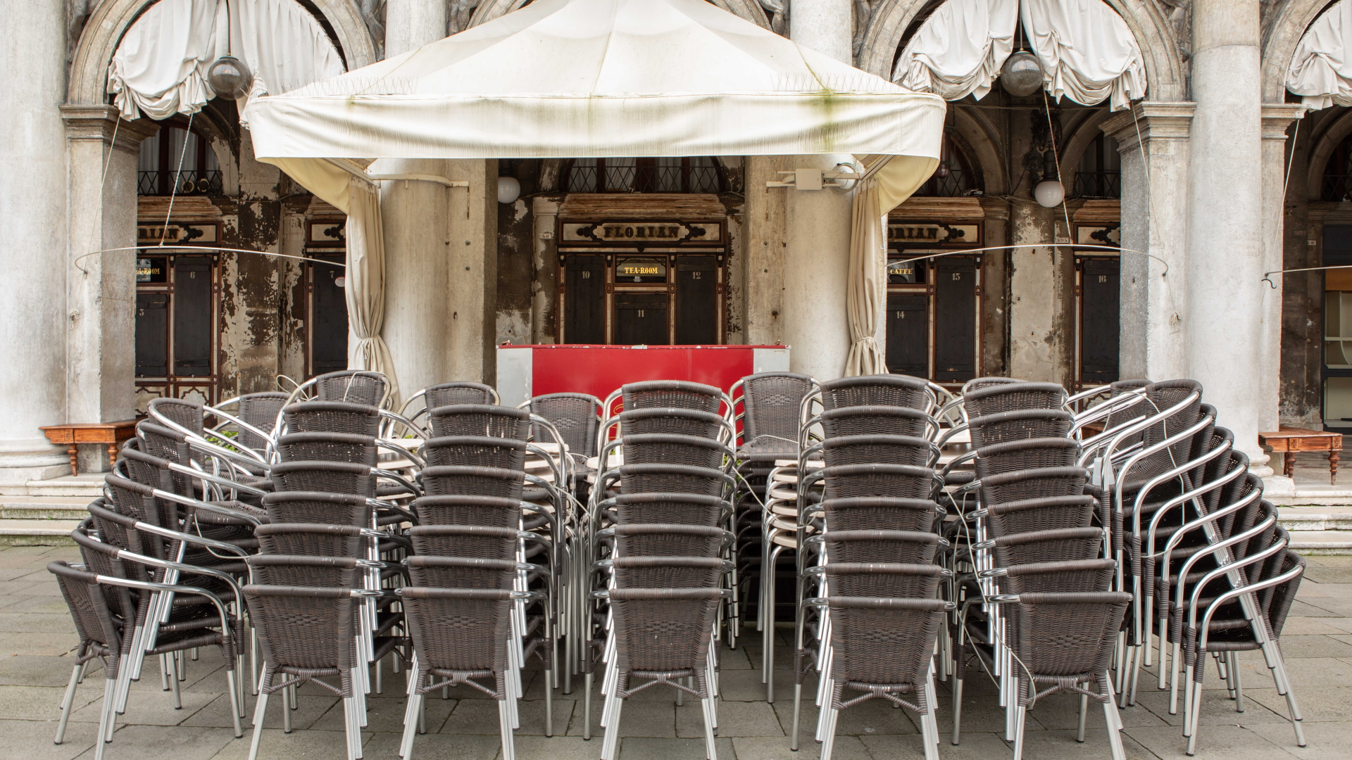 Stühle stehen gestapelt vor einem geschlossenen Café in Venedig | dpa
