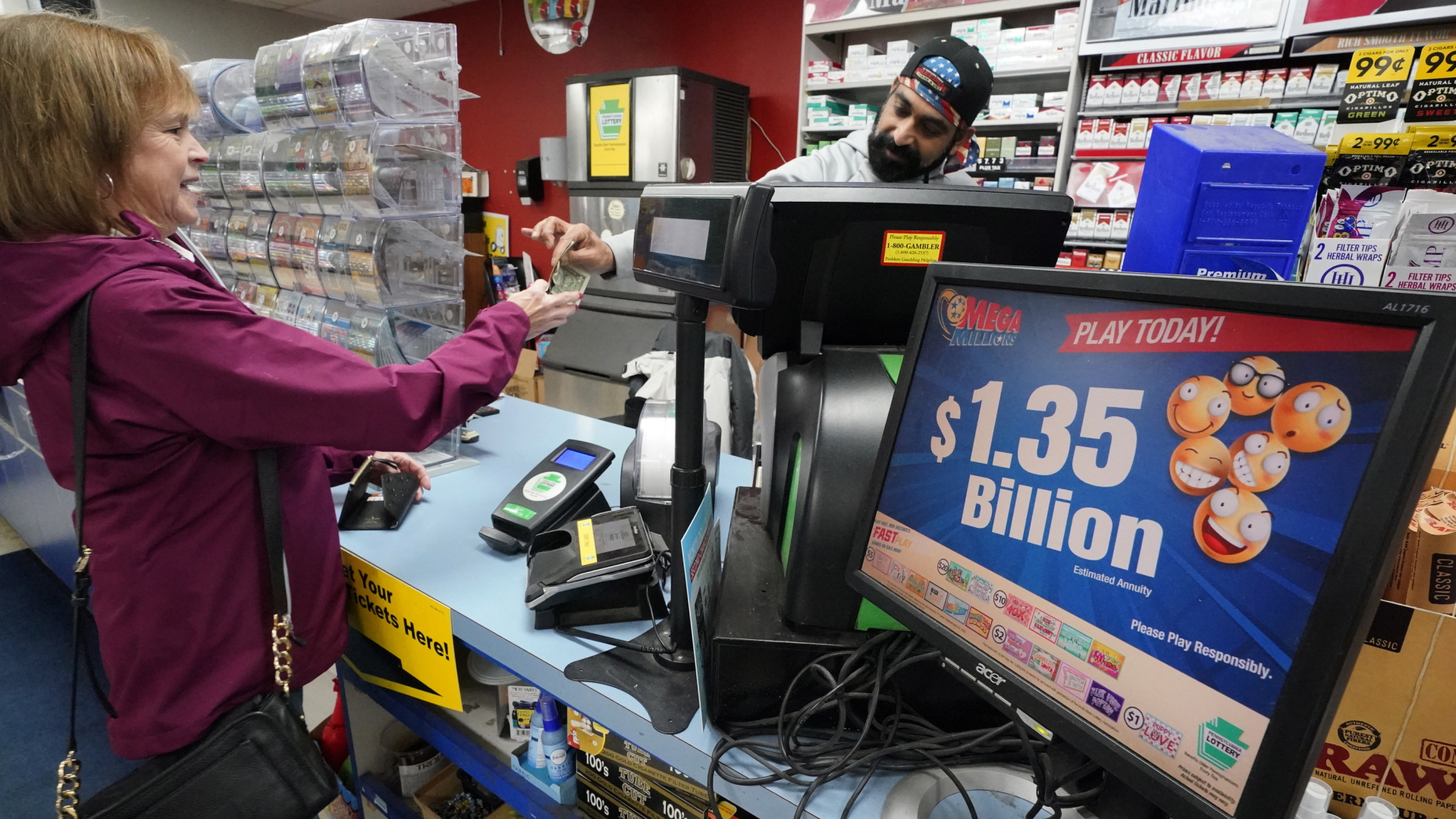 Eine Frau kauft einen Lottoschein, auf einem Display daneben steht der Jackpot von 1,35 Milliarden Dollar.  | AP