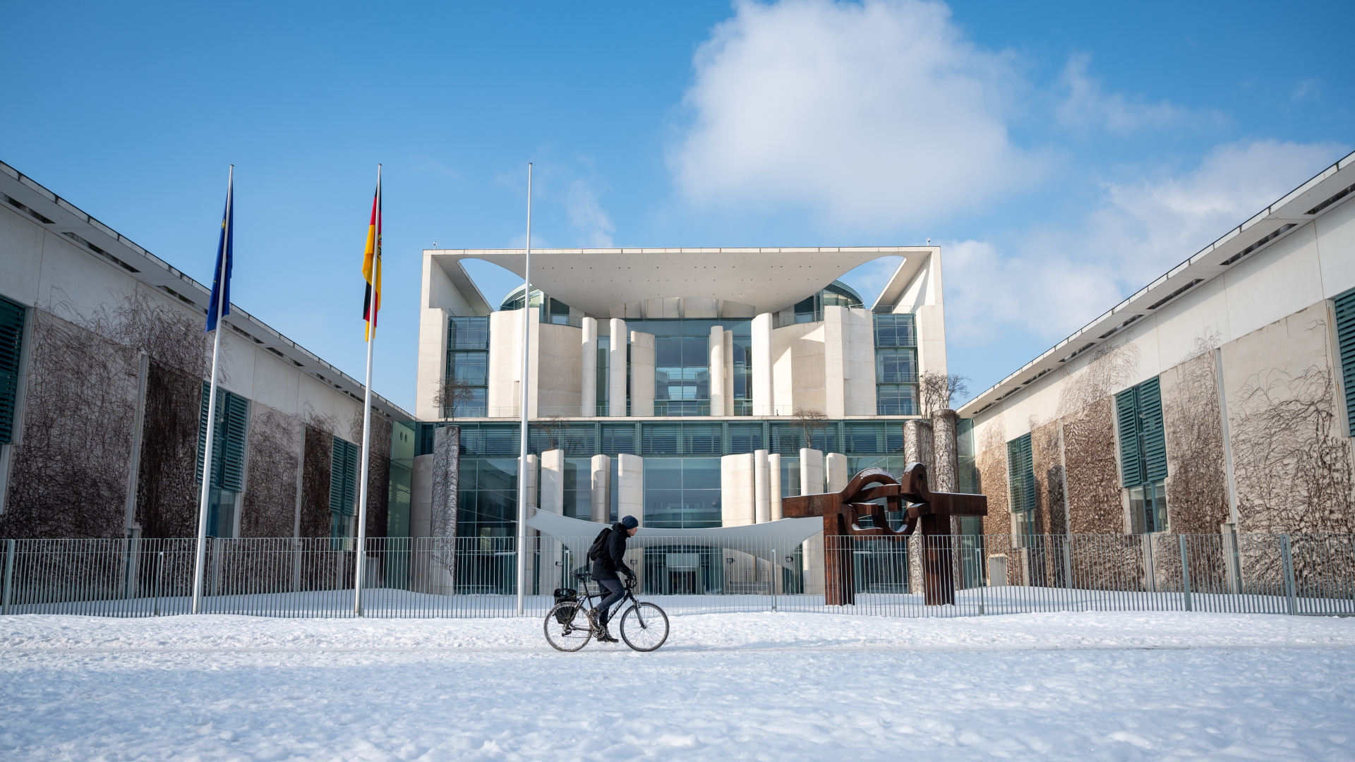 Ein Mann fährt mit seinem Fahrrad vor dem Bundeskanzleramt.  | dpa
