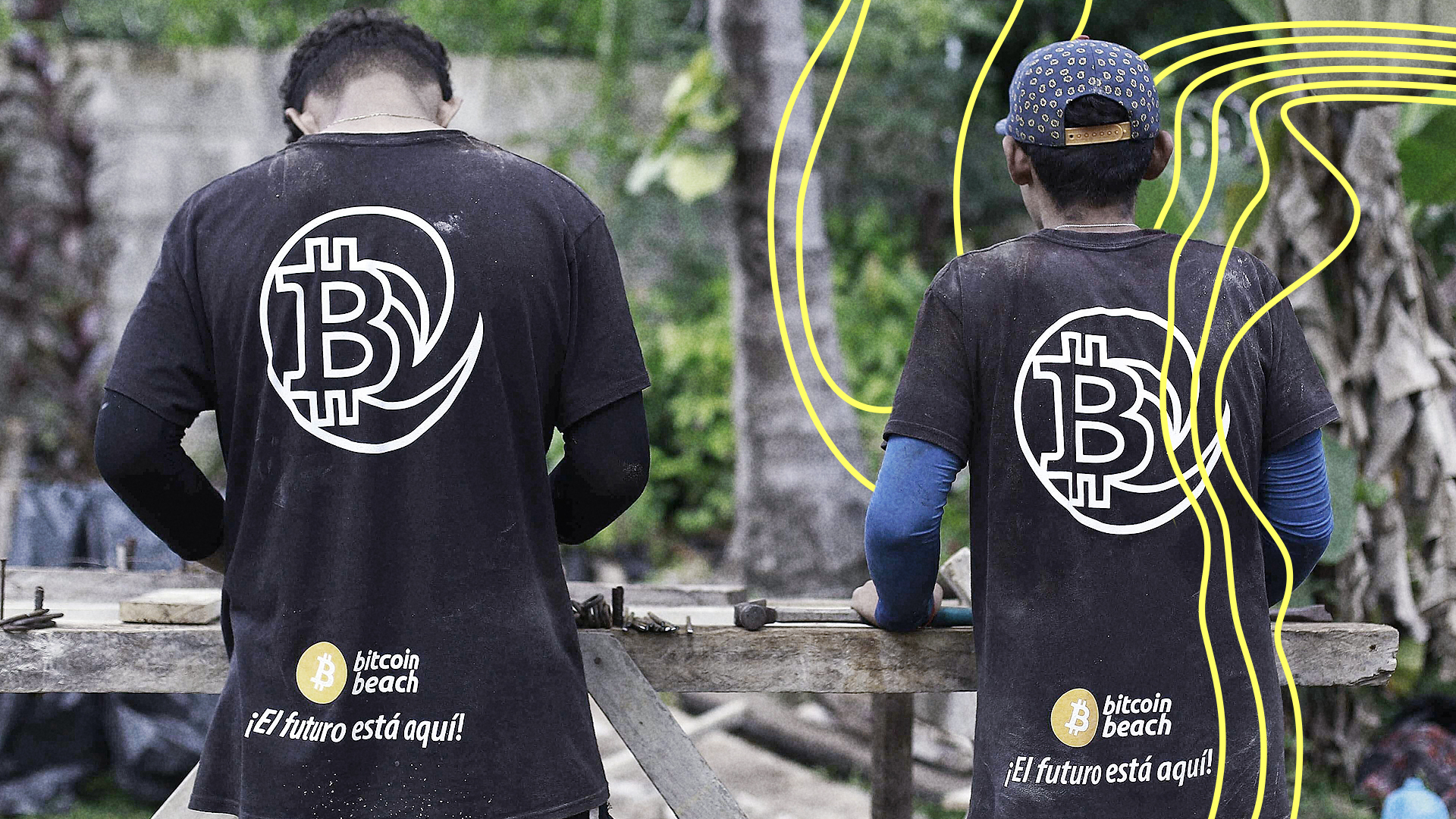 Zwei junge Männer in Bitcoin-Werbehemden arbeiten in Chiltiupan, El Salvador, in einer Schreinerei | IMAGO / Agencia EFE