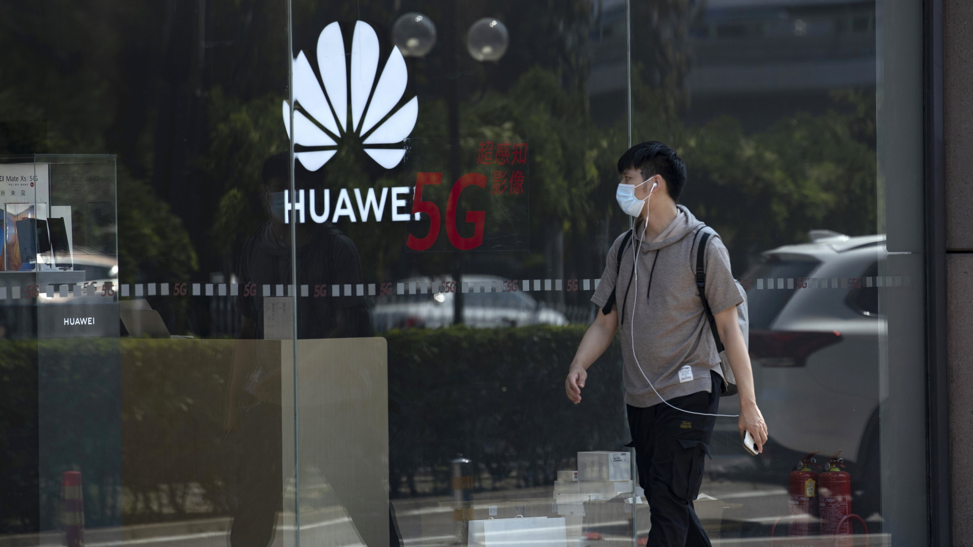 Ein Mann geht an einem Huawei-Laden in Peking vorbei, wo für 5G geworben wird | AP