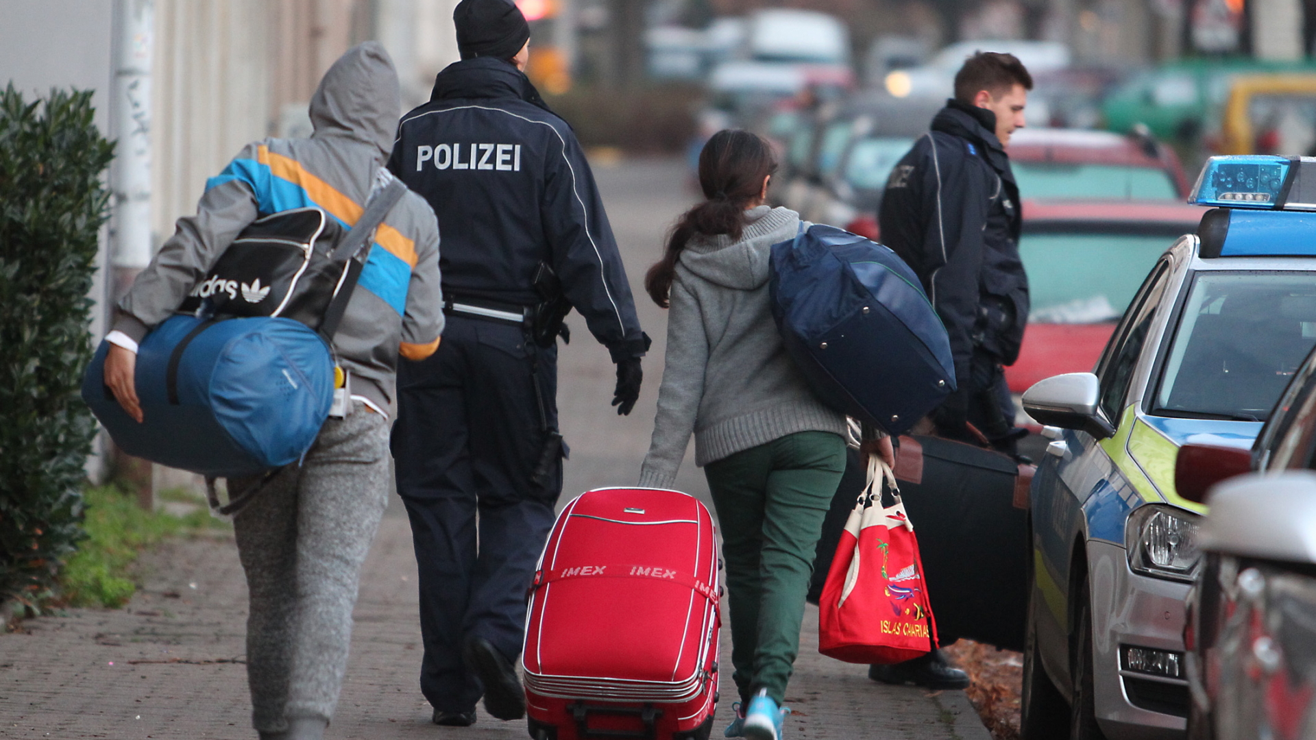 Abgelehnte Asylbewerber werden von Polizisten zum Flughafen gebracht (Archivbild) | dpa