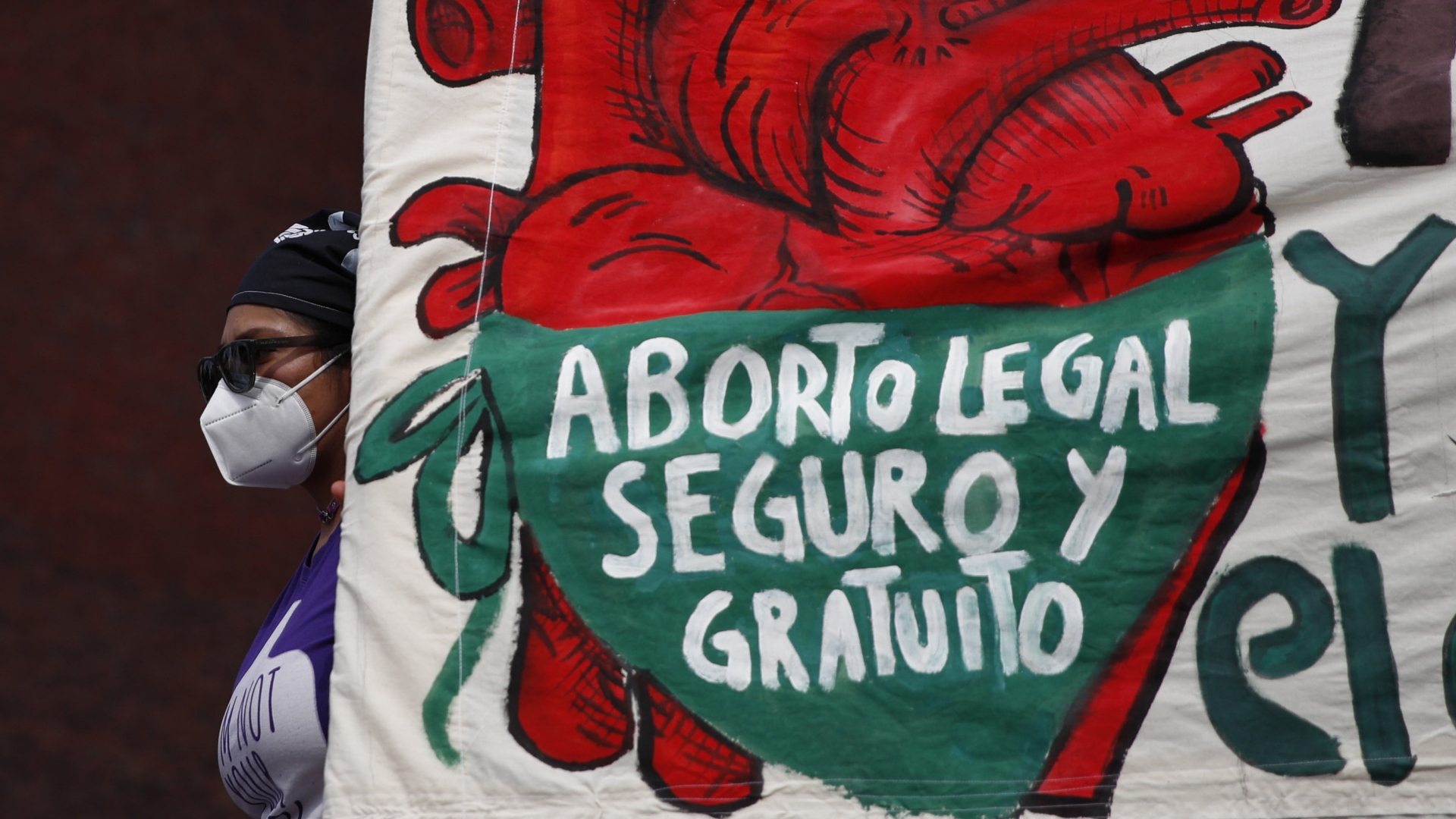 Eine Demonstrantin in Mexiko hält ein Plakat hoch mit der Aufschrift, "Legale, sichere und kostenlose Abtreibungen". | AP