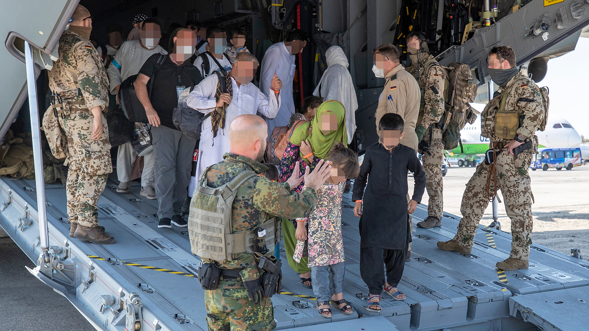 Evakuierte werden von deutschen Sicherungskräften aus dem Airbus A400M geleitet. | dpa