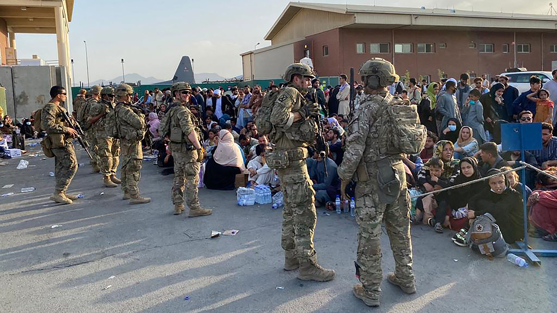 US-Soldaten stehen Wache, während afghanische Bürger darauf warten, ein US-Militärflugzeug in Kabul zu besteigen. | AFP