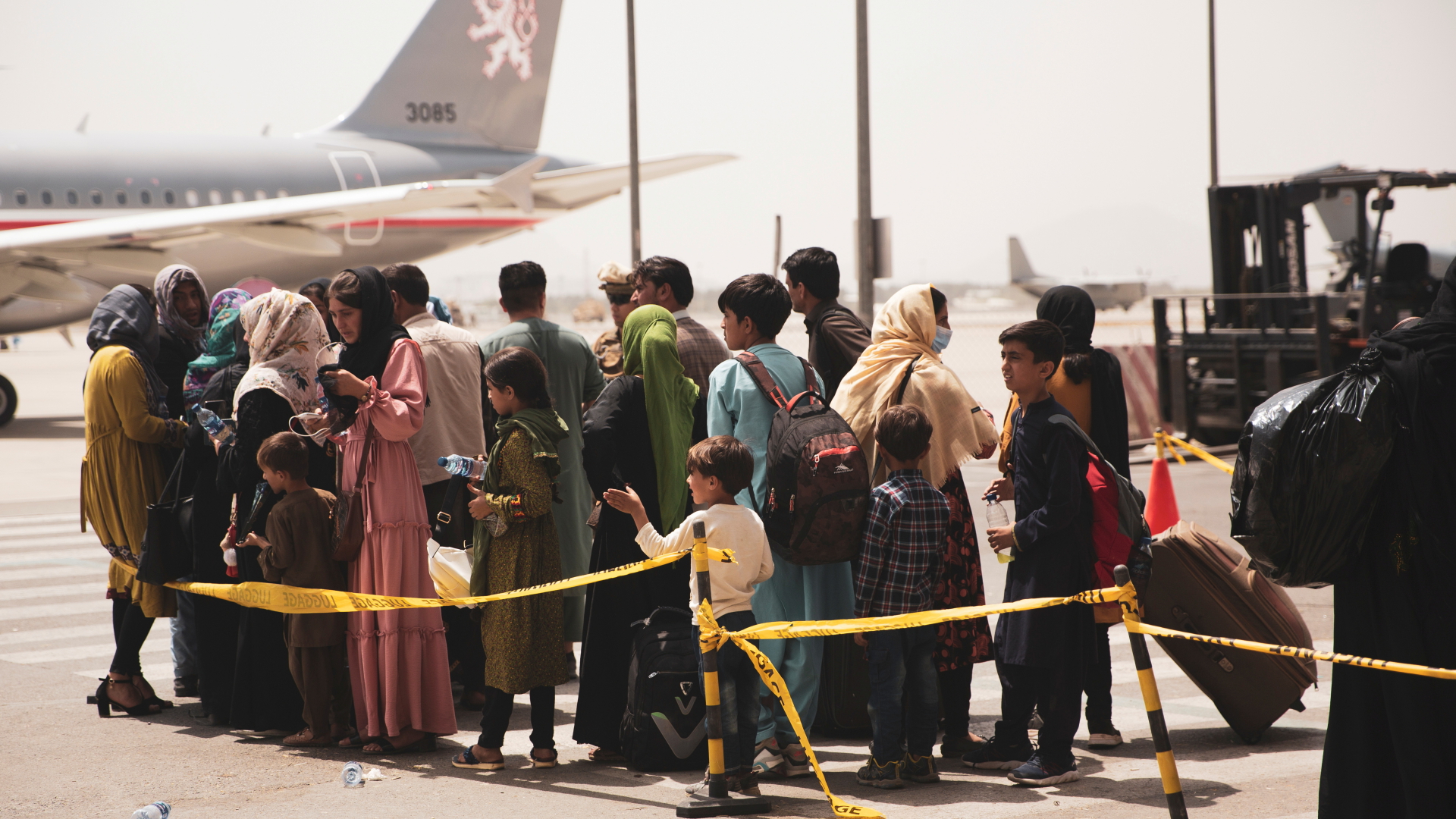 Menschen auf dem Flughafen in Kabul warten darauf ein Flugzeug zu boarden | via REUTERS