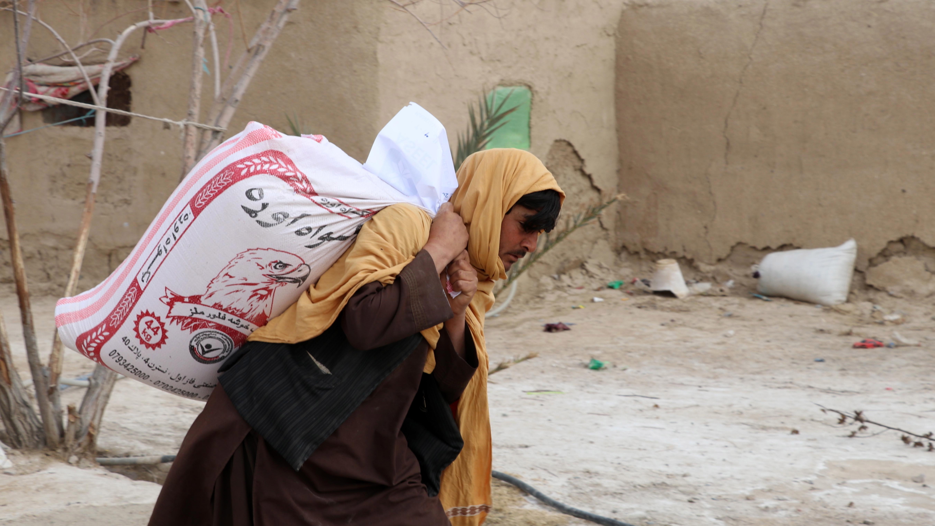 Ein Mann in Afghanistan trägt eine Lebensmittelspende  | EPA