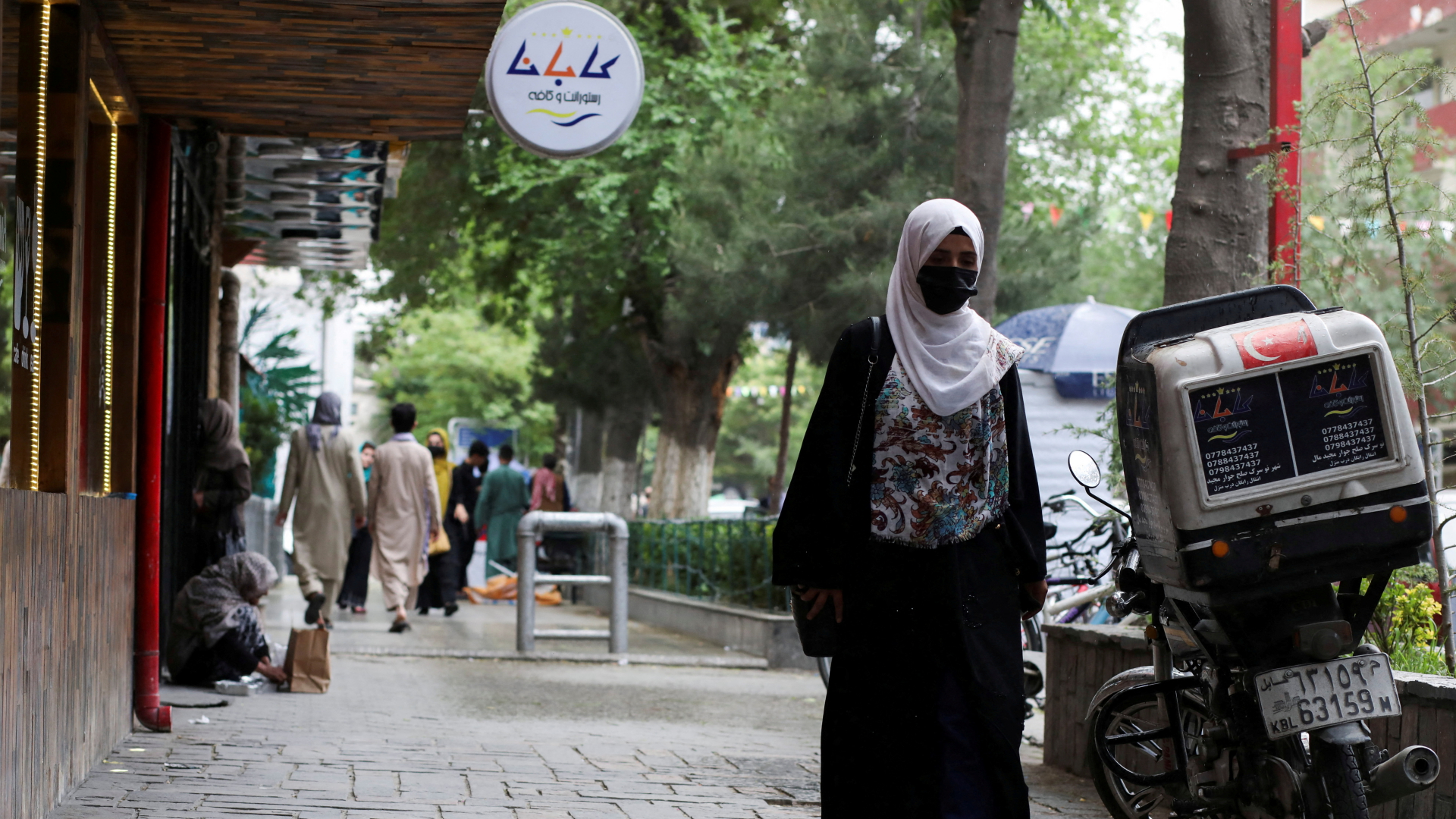 Eine weitgehend verhüllte Frau geht auf einem Fußweg in Kabul. | REUTERS
