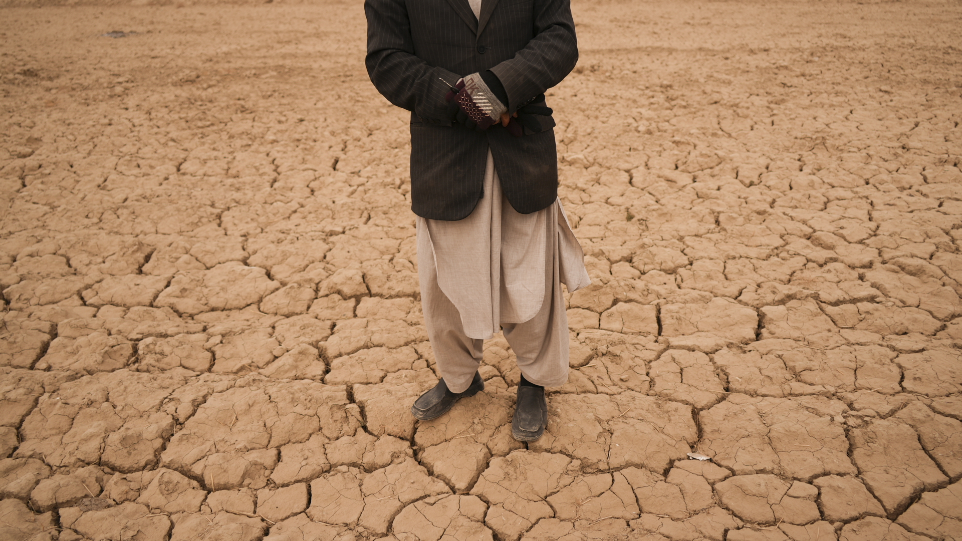 Ein Mann steht in dem Ort Hachka in Afghanistan auf seinem kargen Feld. | dpa