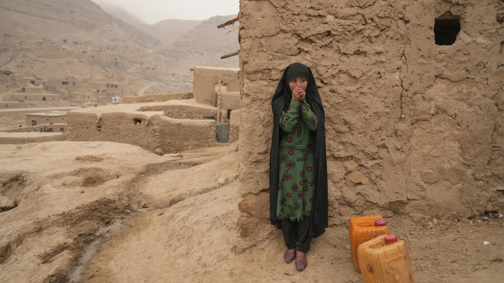 Ein afghanisches Mädchen wärmt sich die Hände, während es sich vom Wassertragen ausruht (Archivbild). 