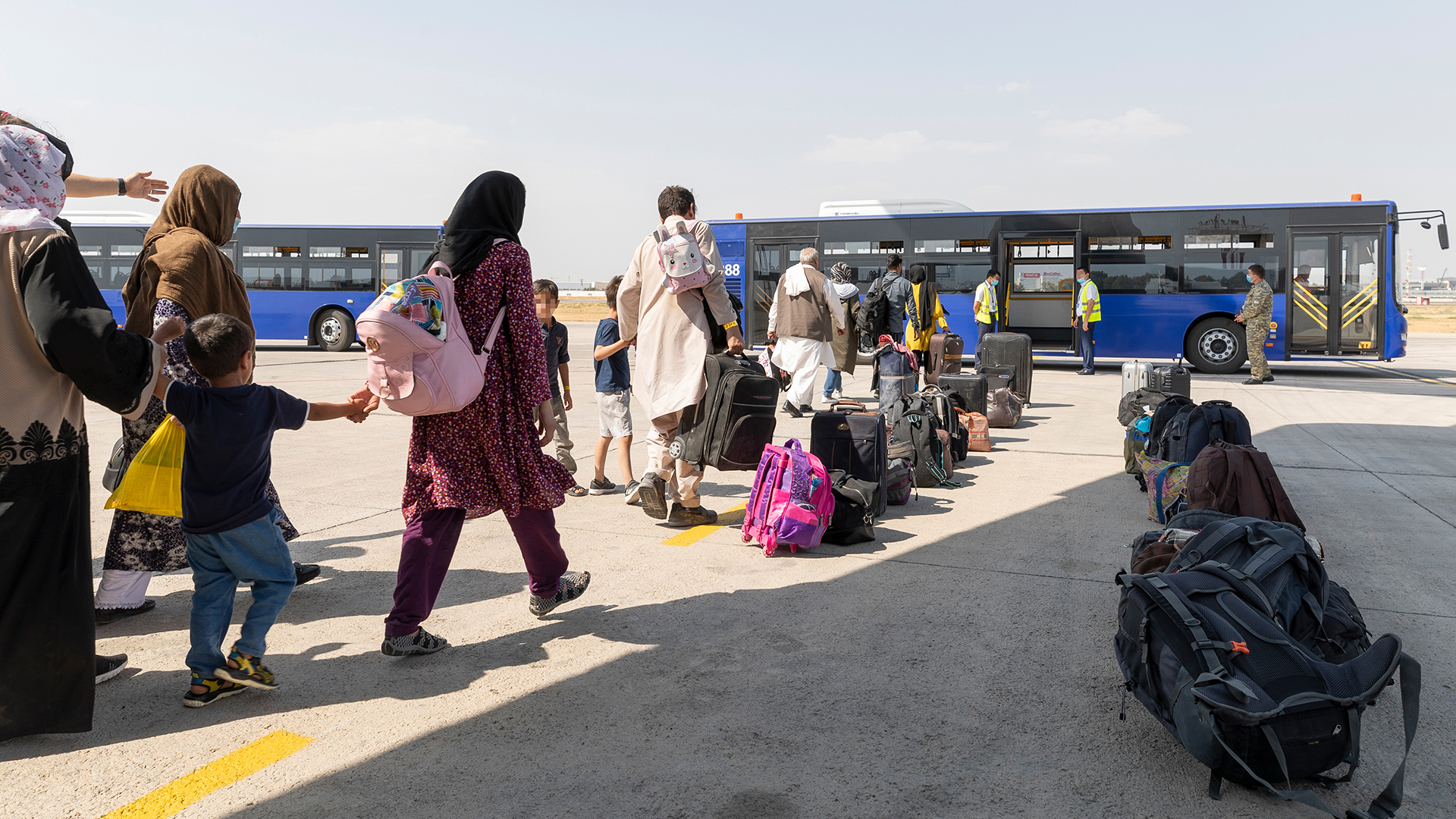 Menschen gehen kurz nach dem Flug aus Kabul zu einem Bus in Taschkent. (Archivbild: 26.08.2021) | dpa