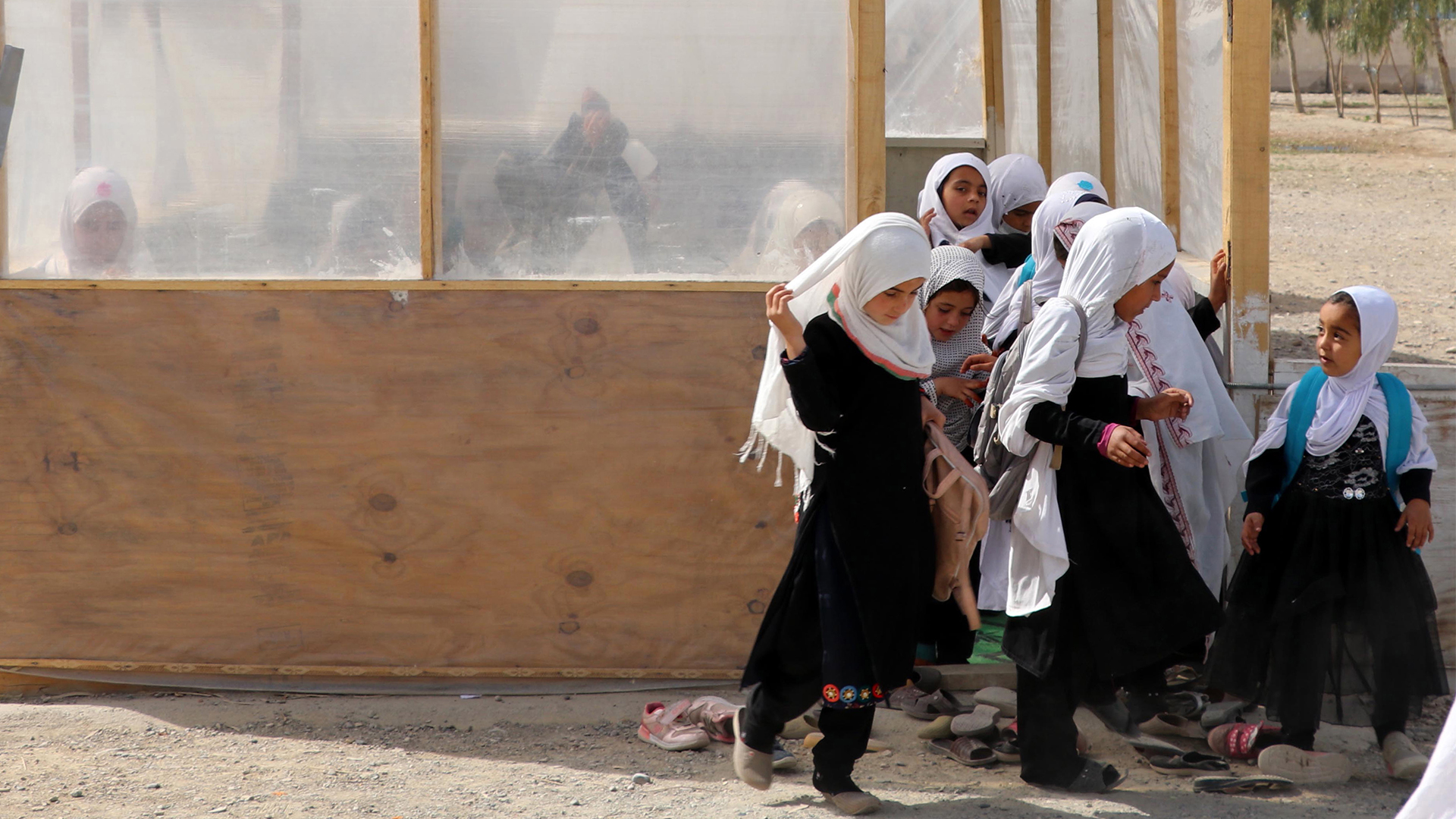 Mädchen in Kandahar, Afghanistan, gehen aus einem behelfsmäßigen Schulraum, der aus Holzpflöcken und Planen gebaut wurde. | EPA