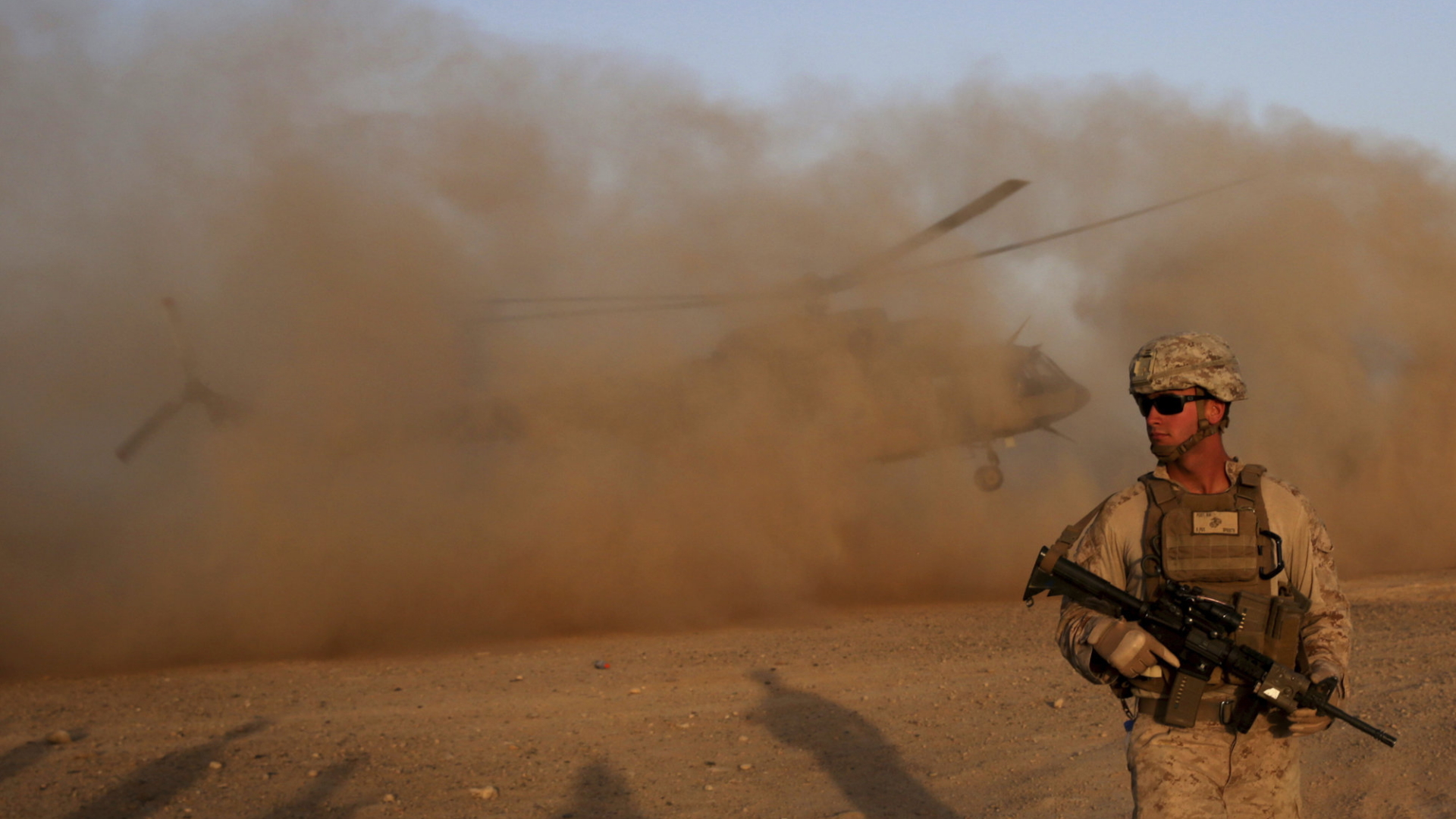 Neben einem in Afghanistan stationierten US-Soldaten steigt ein Helikopter auf. | dpa