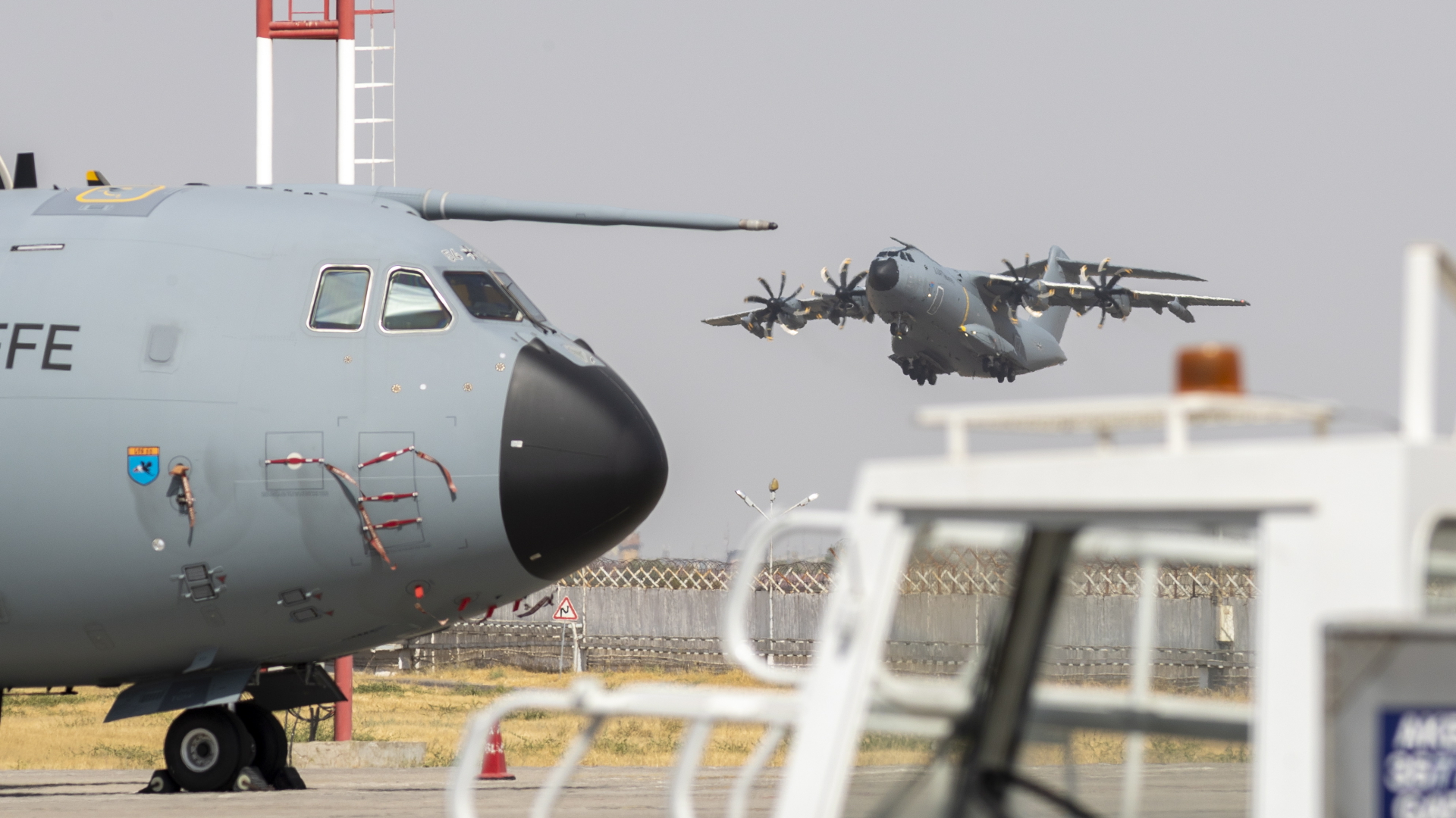 Eine Militärmaschine des Typs A400M steht auf einem Rollfeld auf dem Flughafen in Taschkent, während im Hintergrund ein anderes Flugzeug des Typs abhebt. | EPA