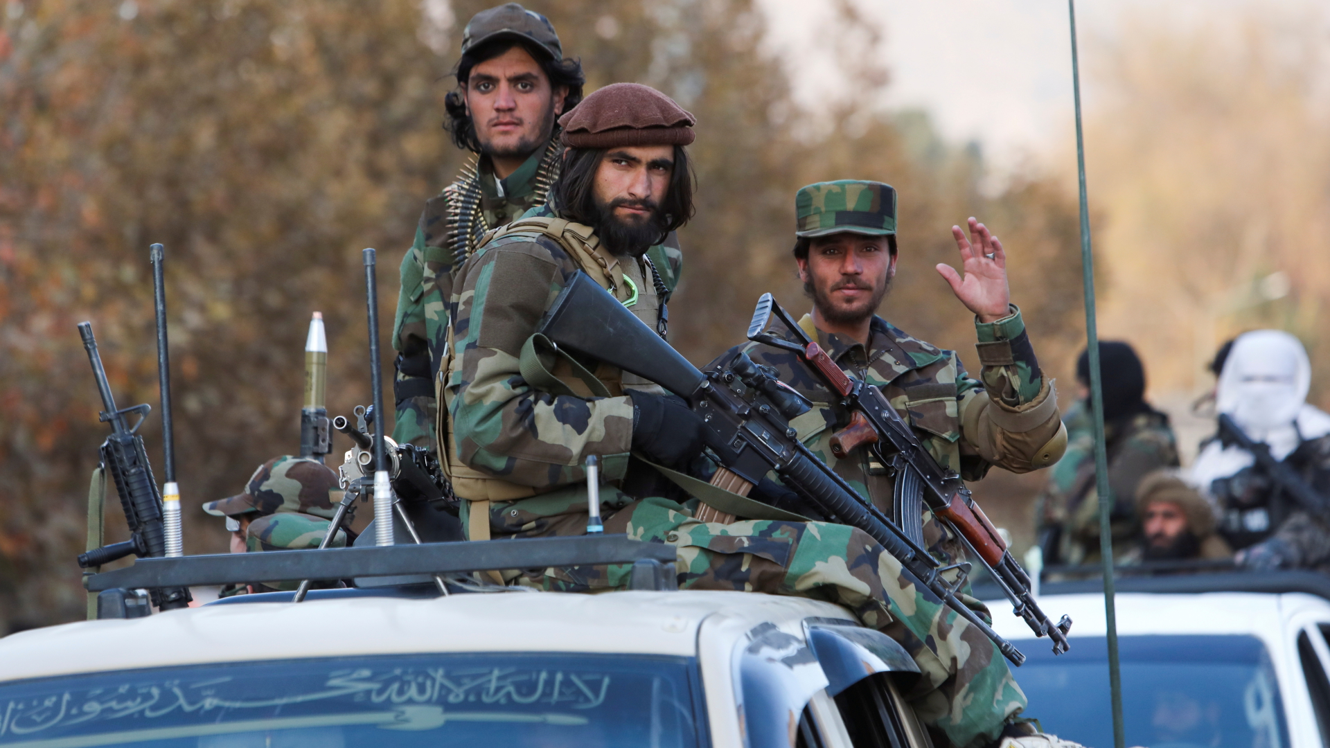 Taliban-Mitglieder sitzen bei einer Parade durch Kabul Mitte November 2021 bewaffnet auf einem Auto. | REUTERS