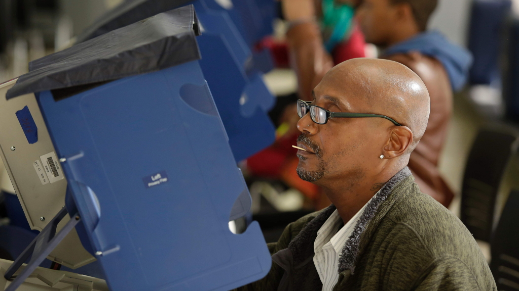Ein afroamerikanischer Wähler gibt an einer Abstimmungsanlage seine Stimme ab. | AFP